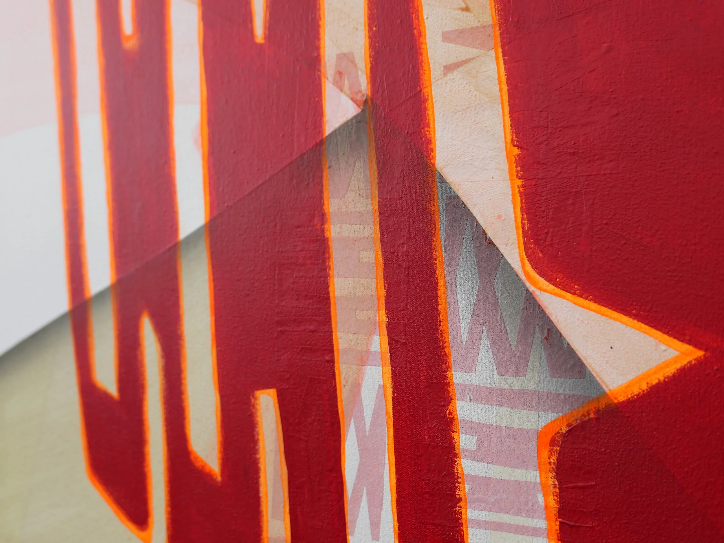 Close-up of a painted sign with red and orange outlined letters on a wall.