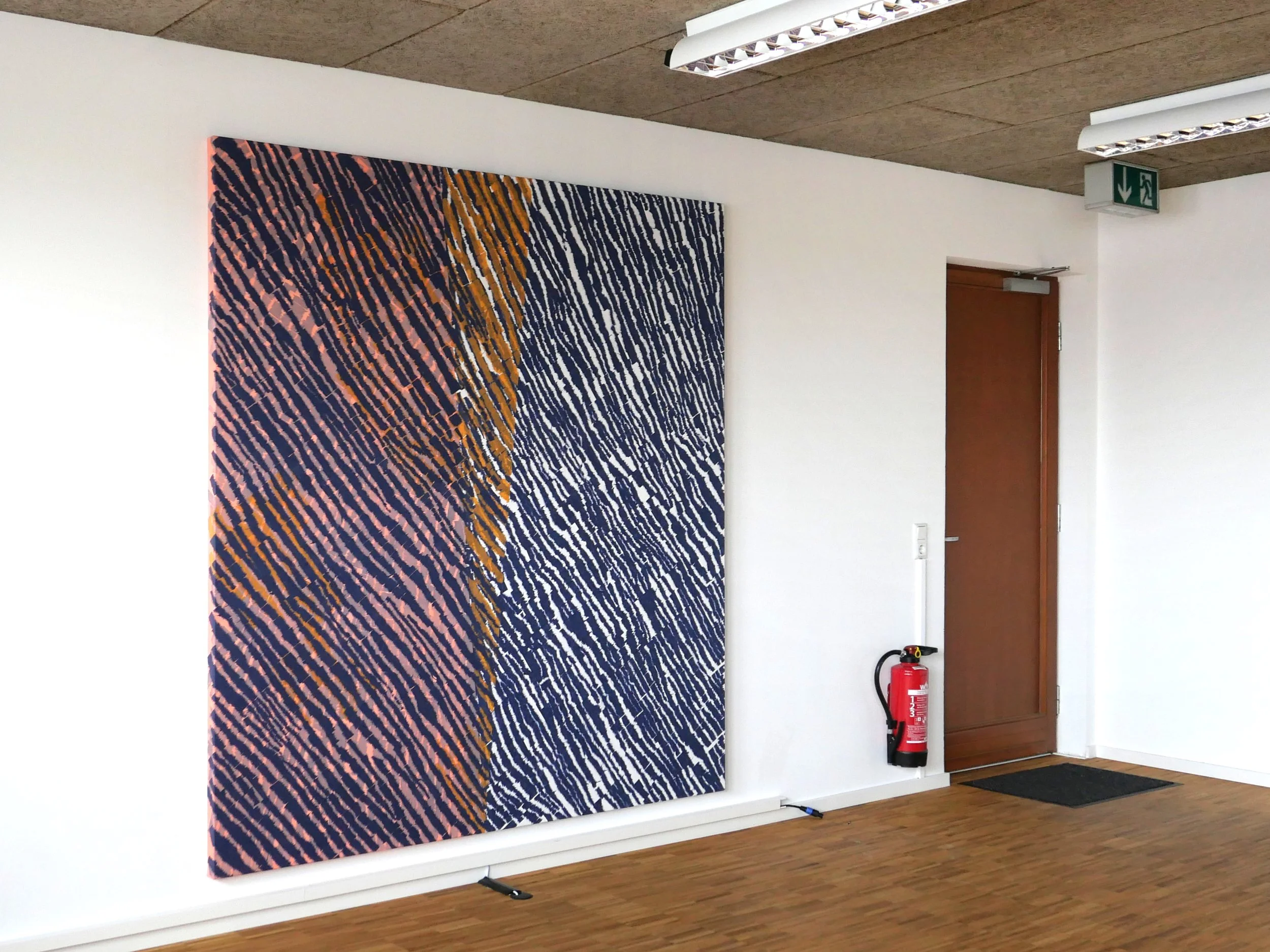 An abstract artwork with wavy lines in black, pink, orange, and white colors on a large canvas leaning against a white wall in a room with wooden flooring.