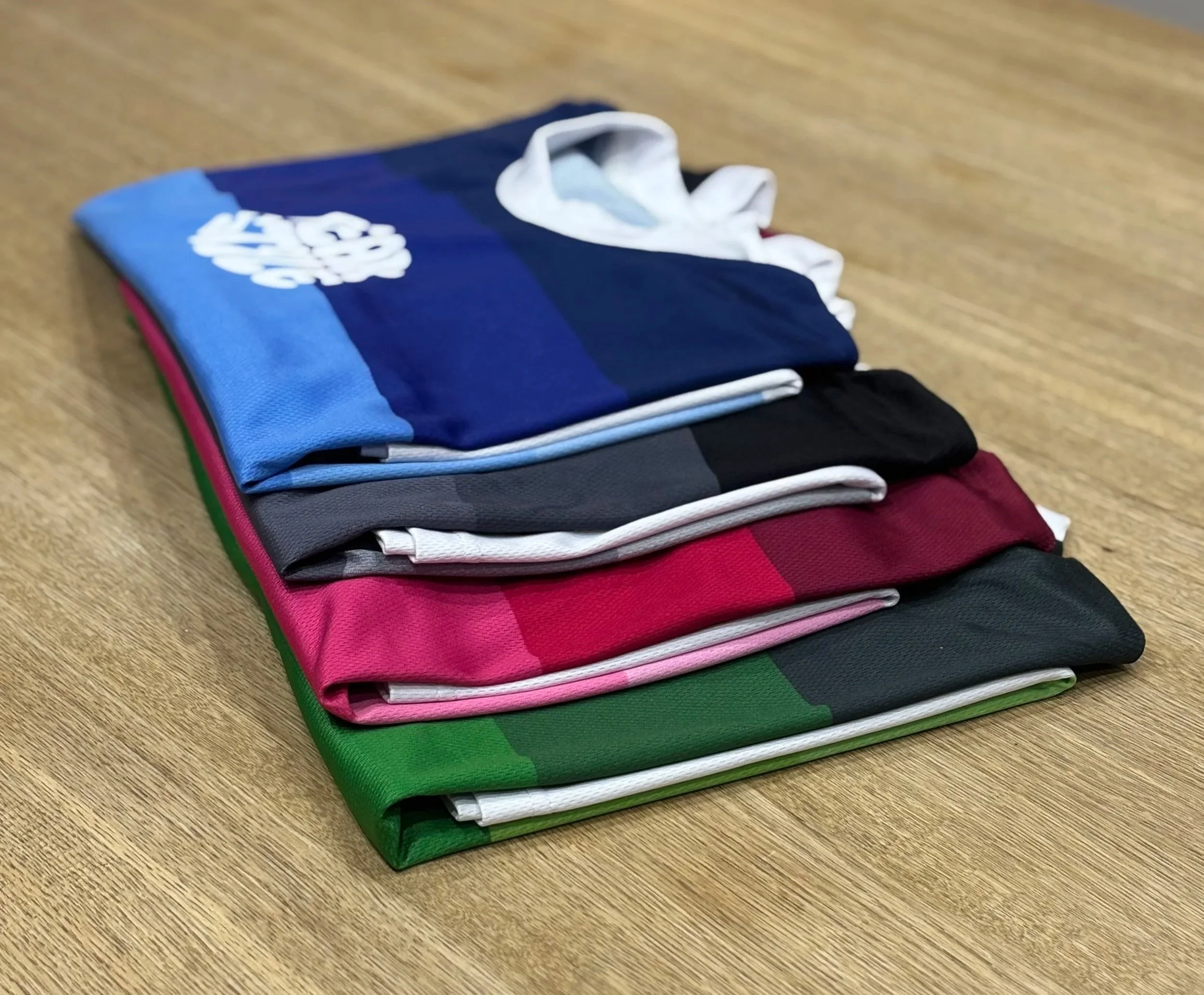 A stack of colorful athletic shorts on a wooden surface.