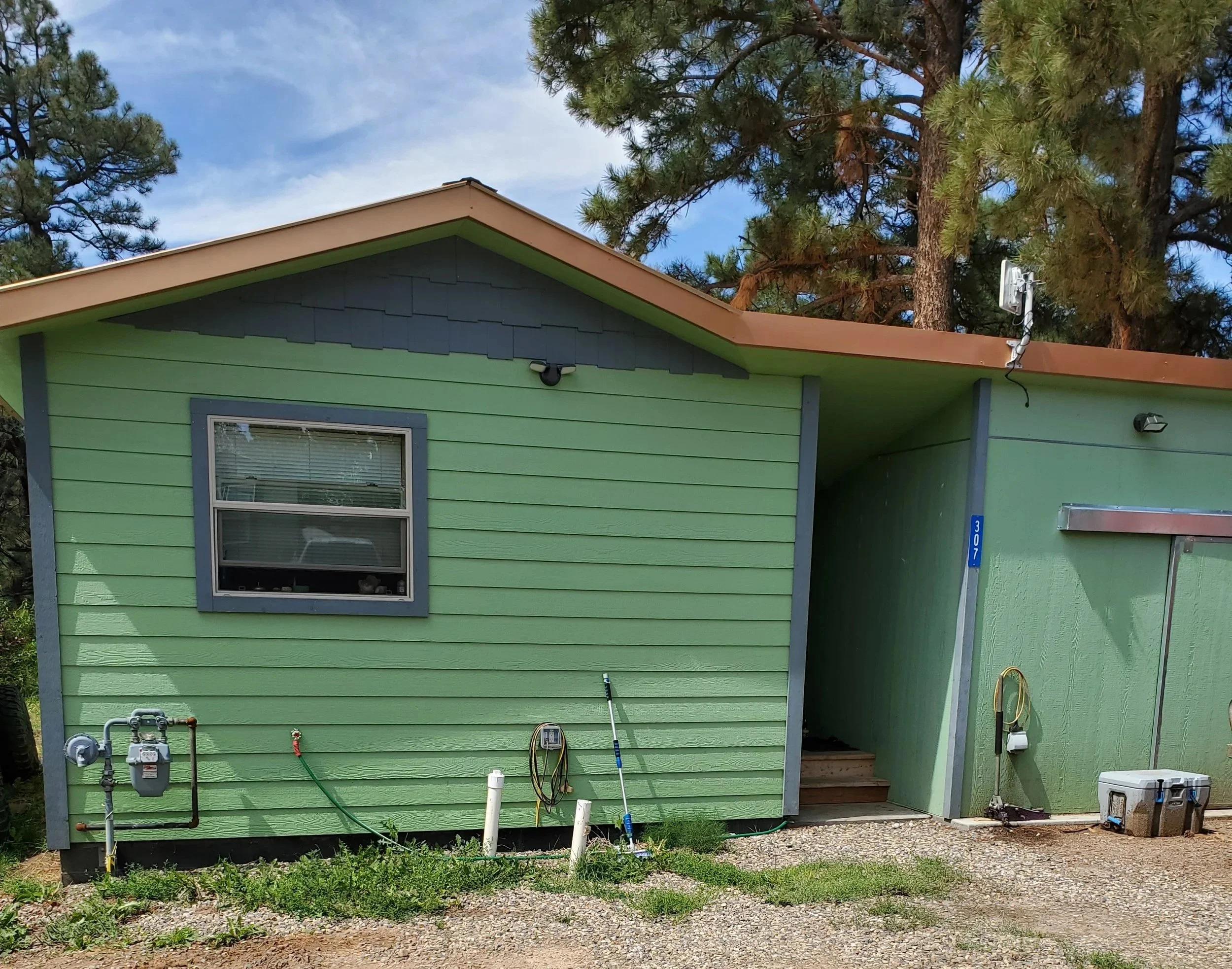 Green house with storage unit attached by copper roof