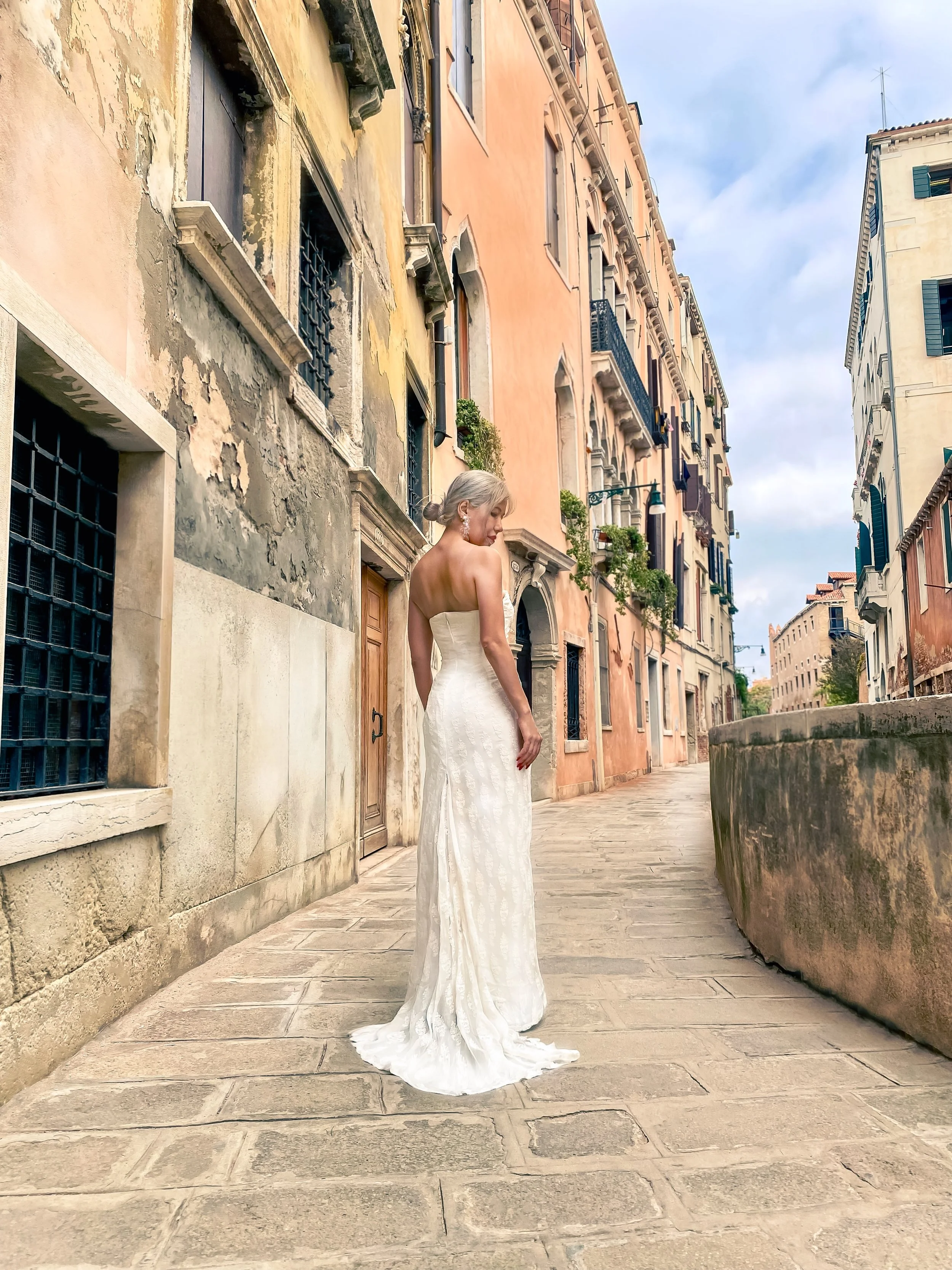 Strapless trumpet wedding dress. Structured corset bodice with a straight neckline. Trumpet skirt flaring below the hips with a subtle train. Crafted from lace over a structured lining.