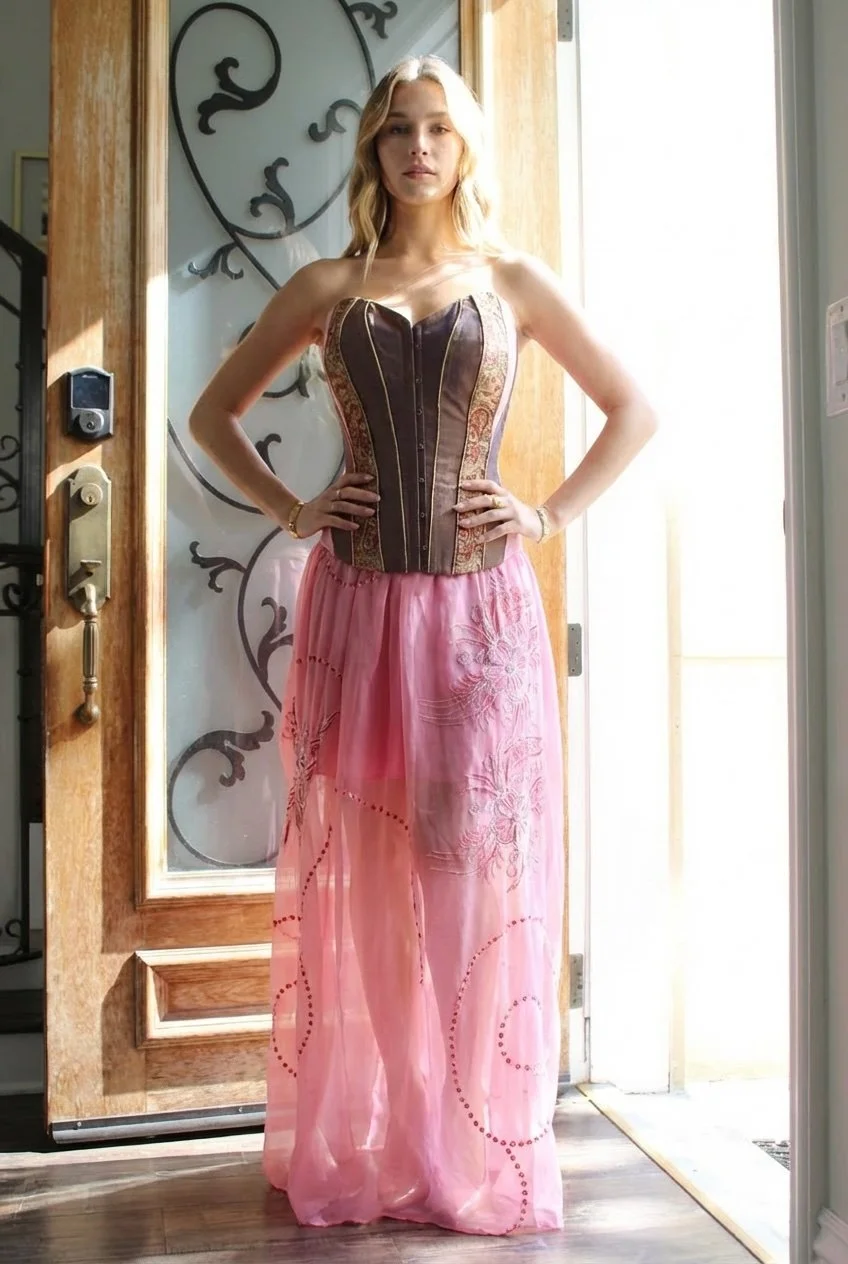 Strapless corset top, shaping the waist. High-waisted, flowing sheer skirt with light volume and delicate embroidery. Floor-length. Silk chiffon for an elegant daytime look.