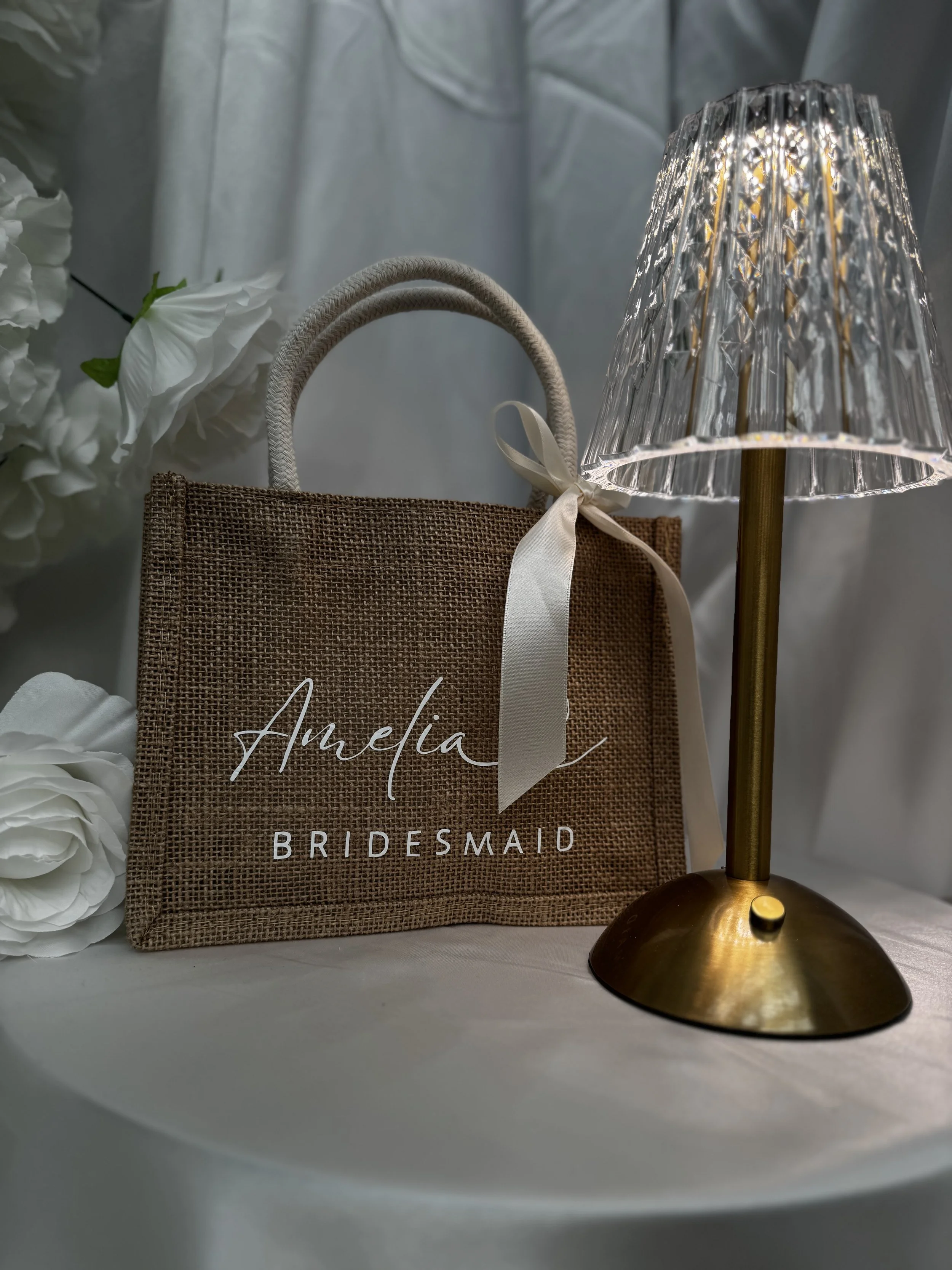 Luxury custom bridesmaid proposal bag sitting on a table with a glowing lamp