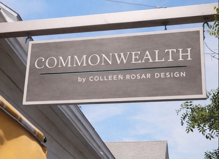 A rectangular sign hanging outside a building reads "COMMONWEALTH by COLLEEN ROSAR DESIGN."