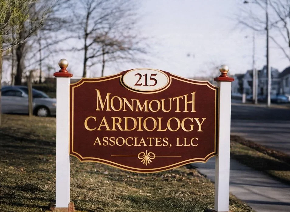 A sign for Monmouth Cardiology Associates, LLC, with the address 215, on a grassy area near a street.
