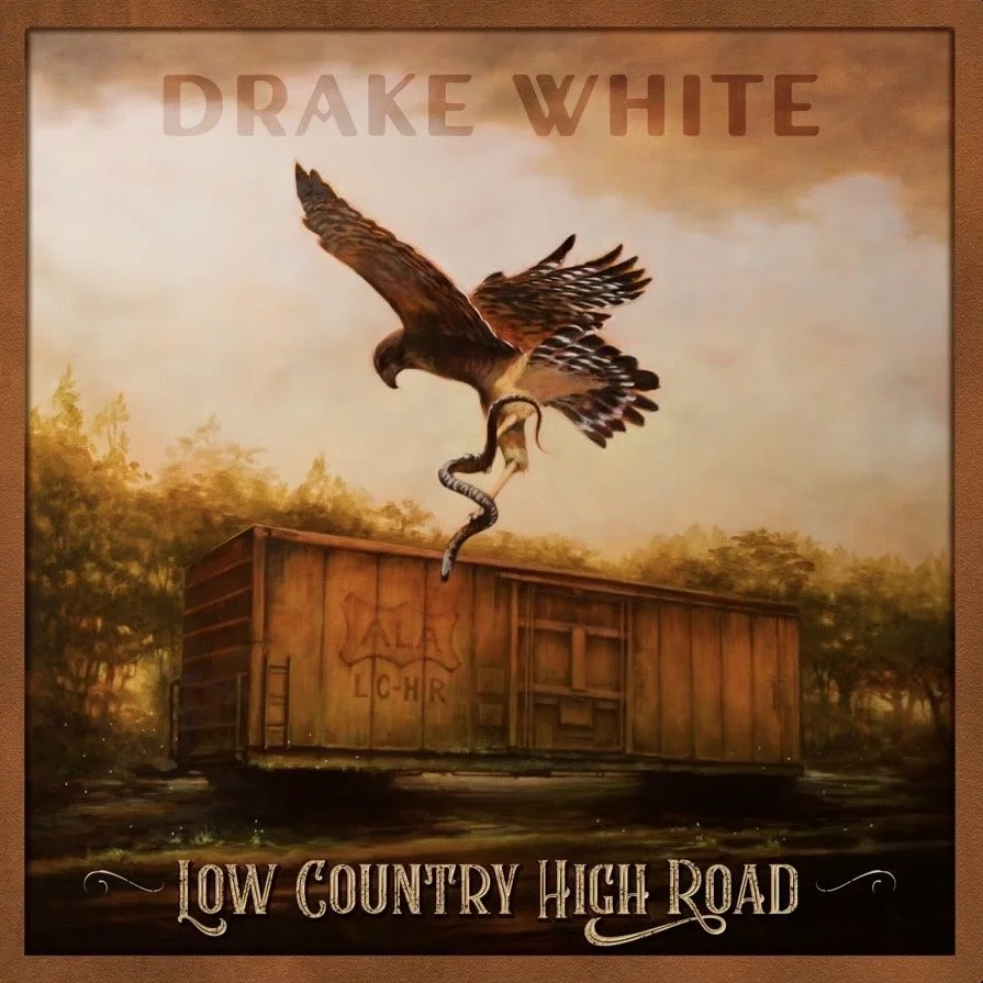 Album cover with an eagle catching a snake flying above a wooden train car, with trees and a sunset sky in the background. Text on the cover reads "Drake White" at the top and "Low Country High Road" at the bottom.