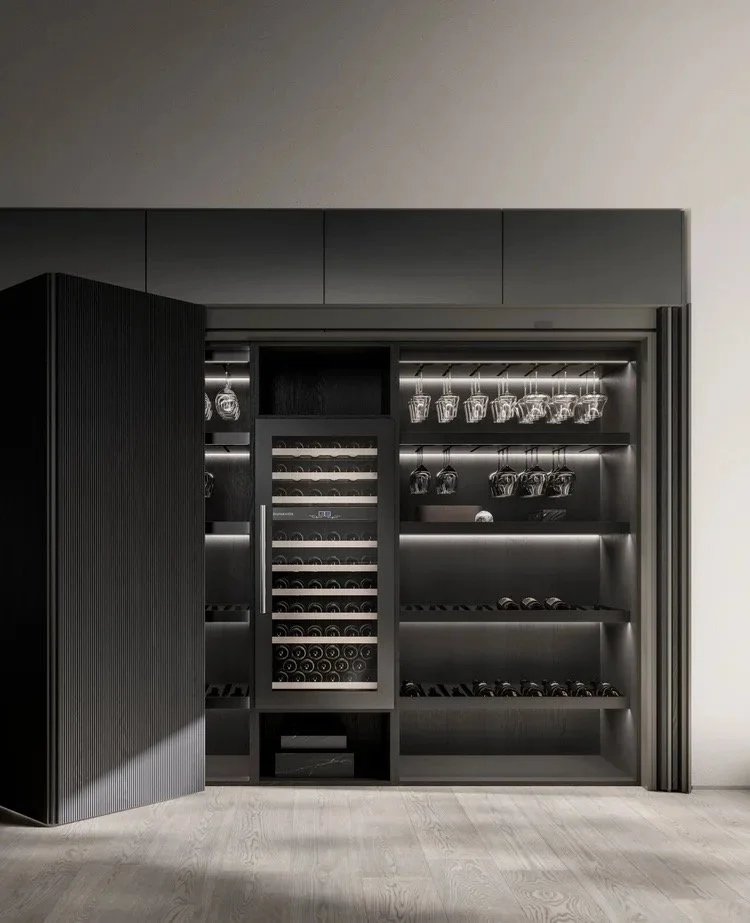 Cuisine contemporaine Pedini, Placard avec portes pliantes rentrantes, Une cave à vin noire avec des étagères contenant des verres à vin suspendus et des bouteilles de vin, avec une porte en partie ouverte.