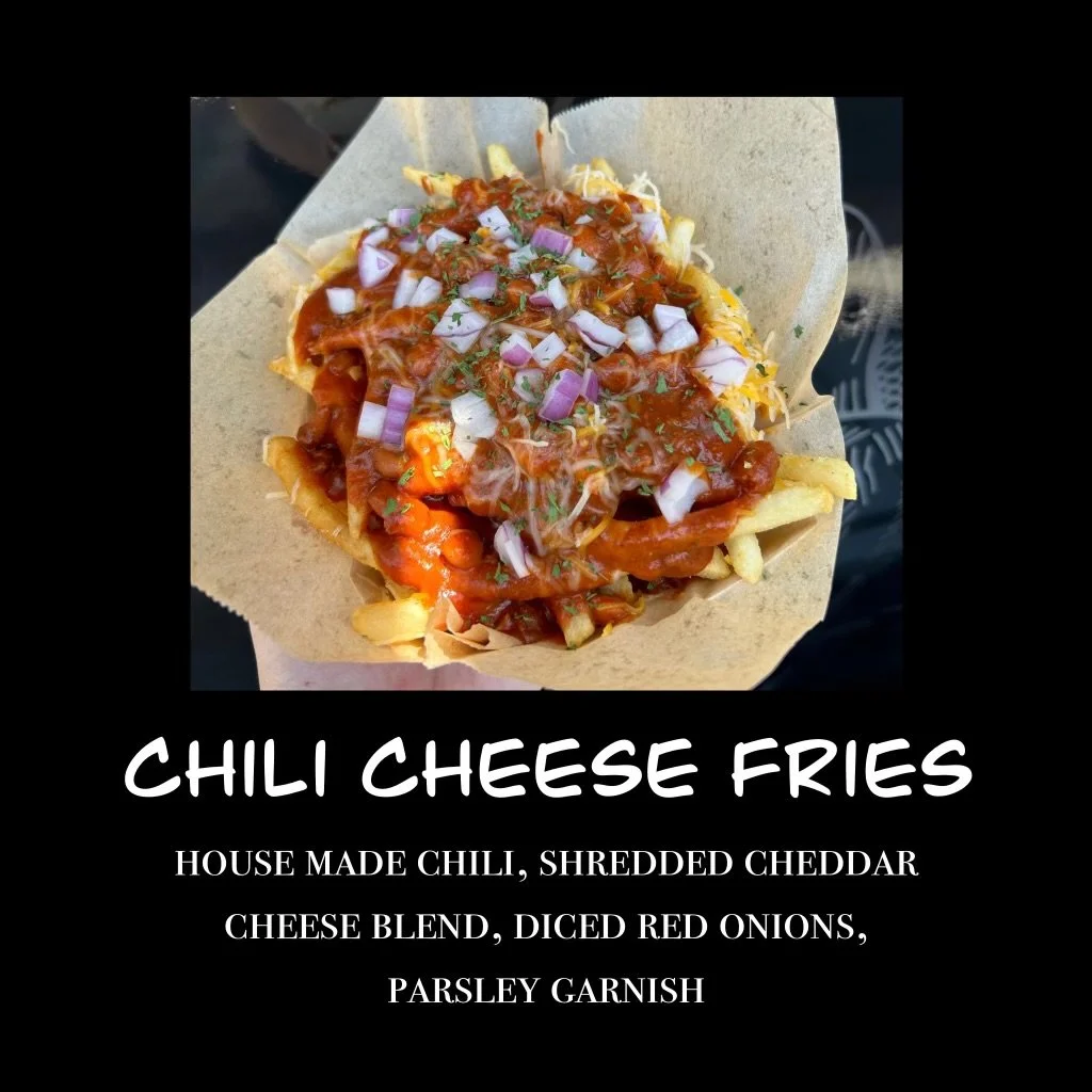 A paper tray with chili cheese fries topped with diced red onions and parsley garnish, served with chili, shredded cheddar cheese, and cheese blend.
