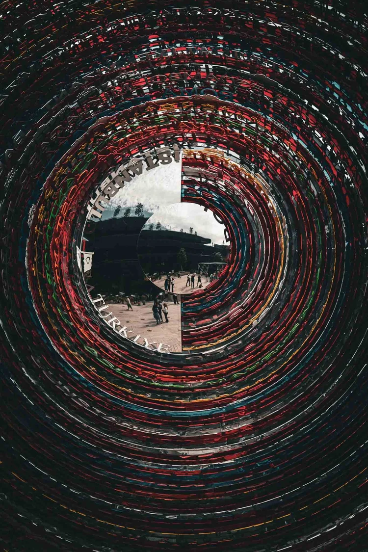 A small central view framed by concentric rings of richly colored, textured material.
