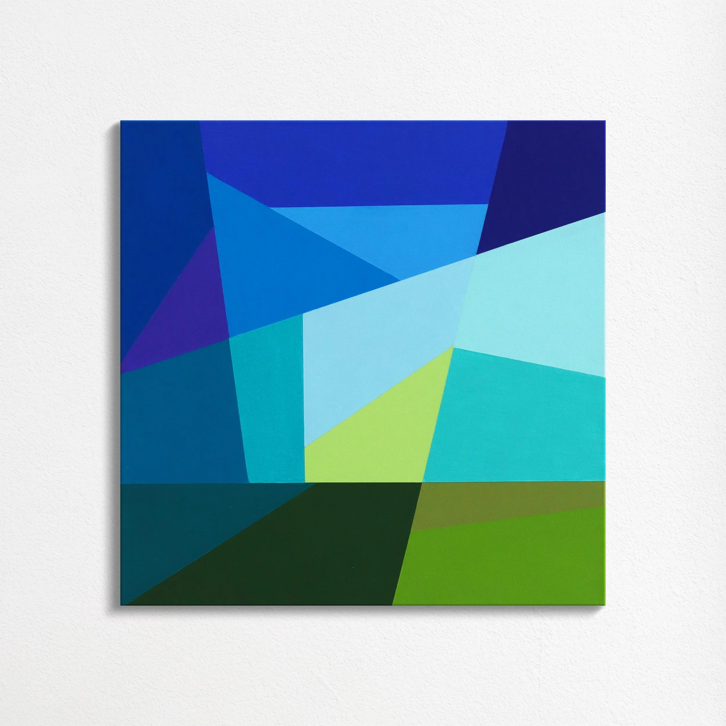 Abstract geometric painting with various shades of blue, green, and purple on a white wall.