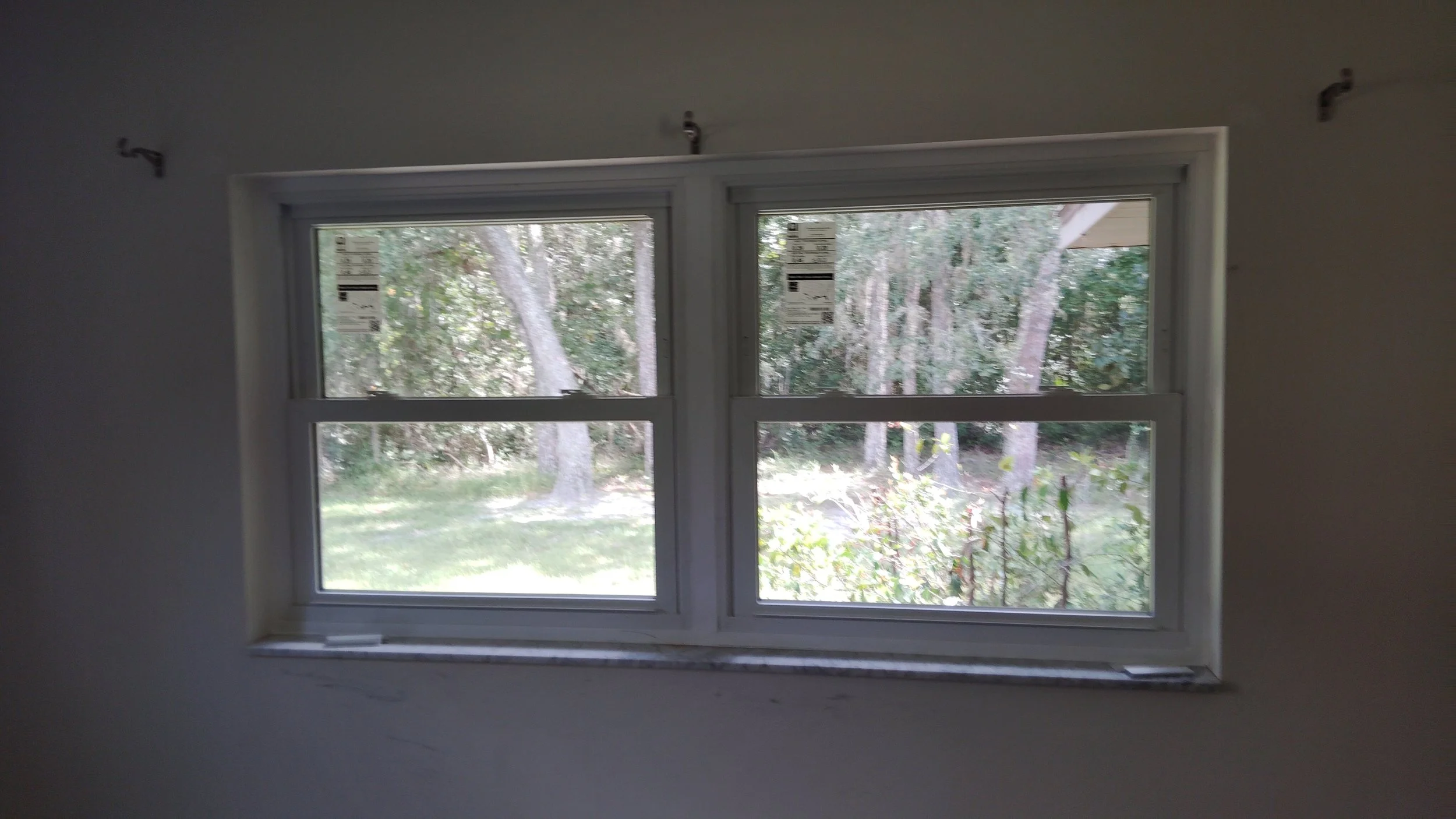 Two residential windows installed evenly with clean interior finish