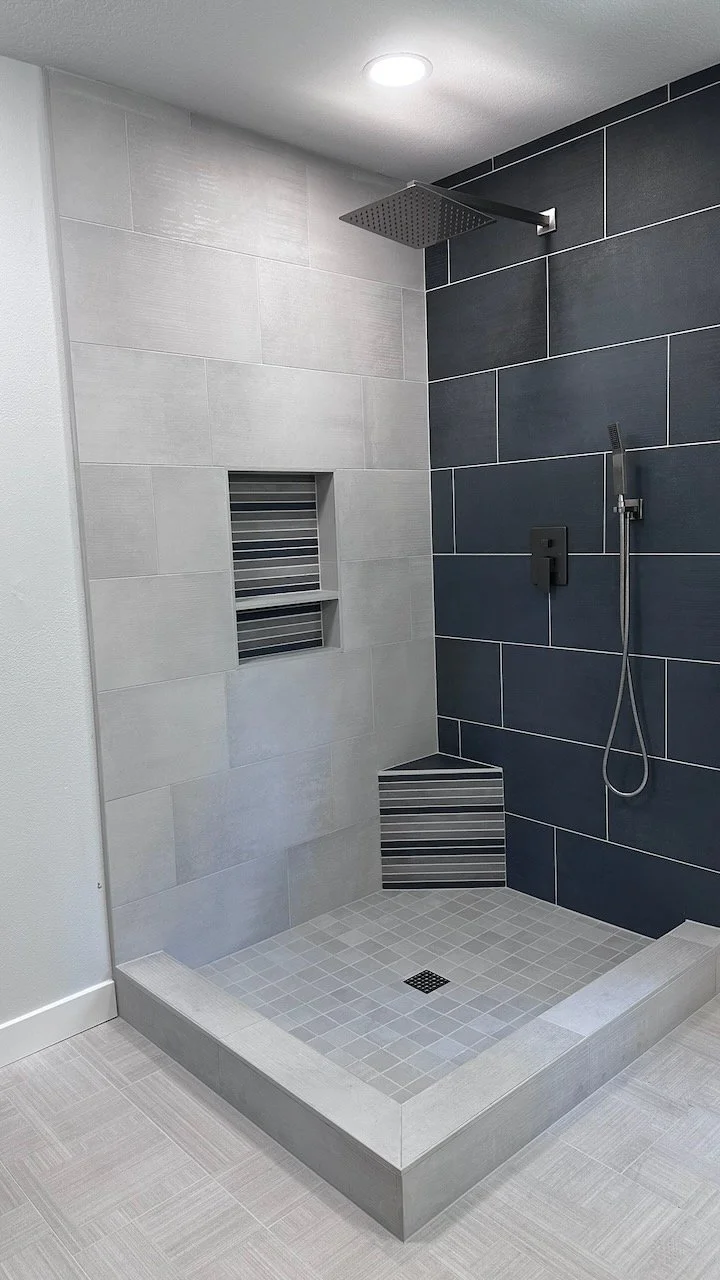Walk-in shower with contrasting dark wall tile and a recessed niche.