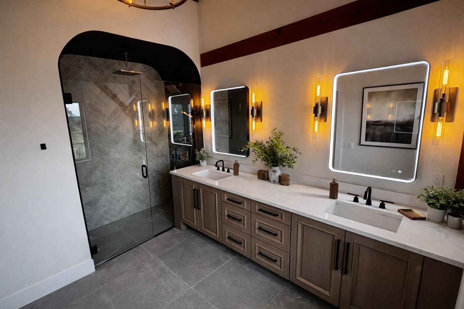 Modern bathroom featuring a double vanity with two illuminated mirrors, two sinks, black fixtures, and a shower with a glass door and grey stone tile walls.