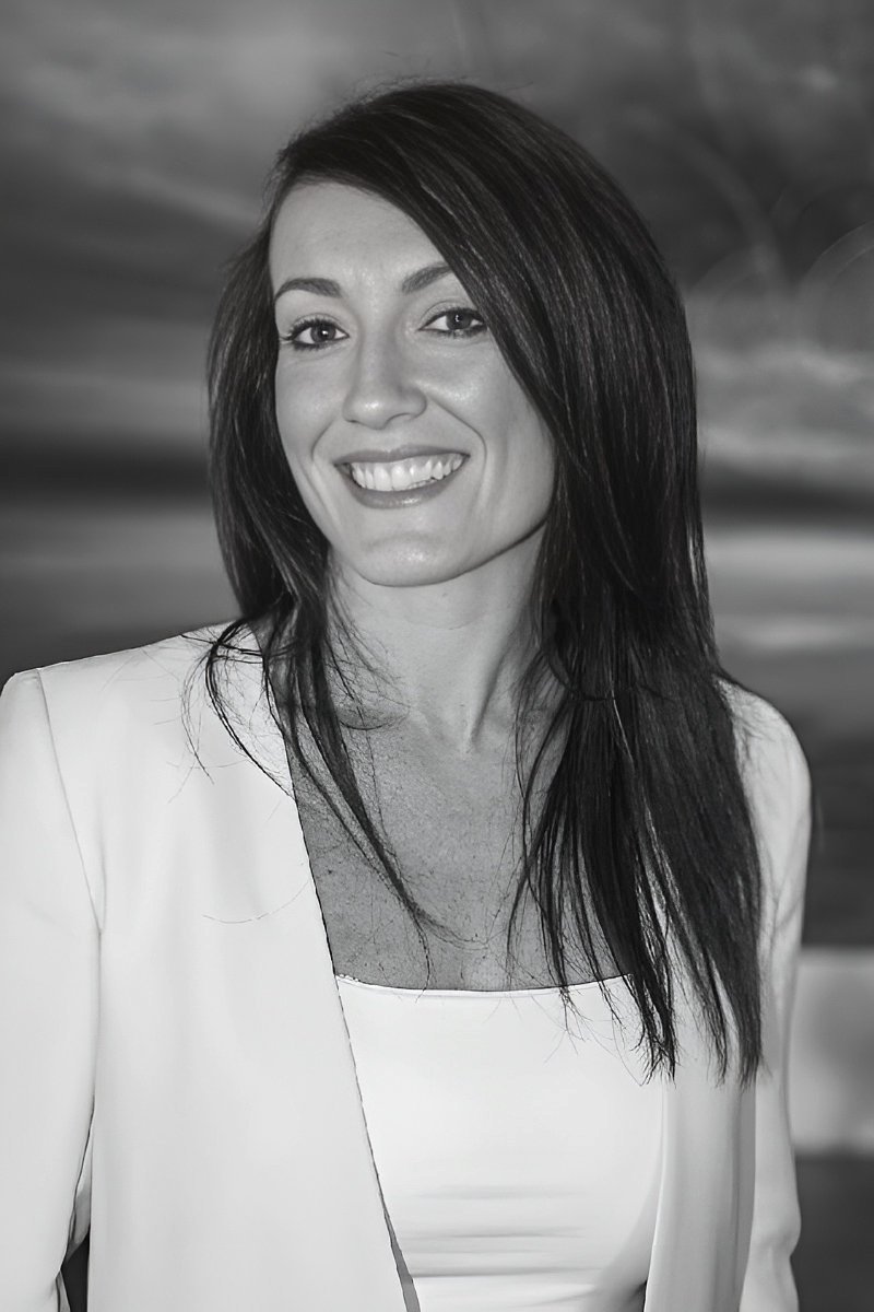 Kerry Christie smiling in a white top and jacket, self-love mentor and healing guide