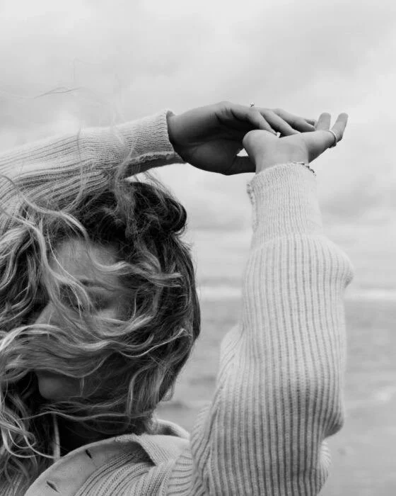 Femme laissant le vent passer dans ses cheveux illustrant un apaisement émotionnel et un lâcher-prise en thérapie
