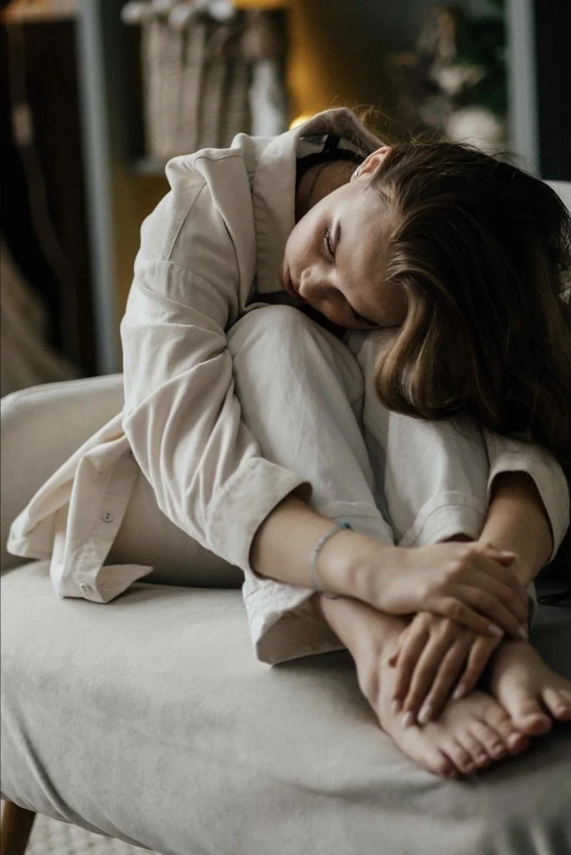 Femme recroquevillée sur elle-même illustrant une fatigue émotionnelle et un repli sur soi