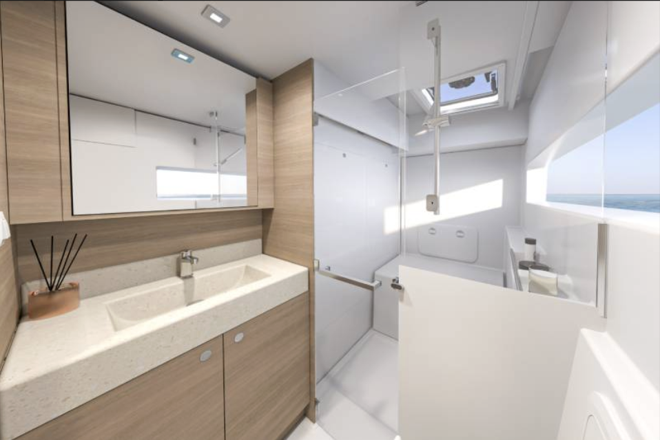 Modern bathroom with wooden cabinetry, a double sink, a large mirror, and a walk-in shower with glass doors; illuminated by natural light from a window showing the ocean view.