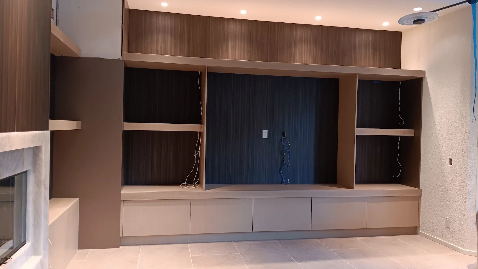bespoke TV wall systems featuring custom wood paneling, integrated cabinetry, and concealed media storage,