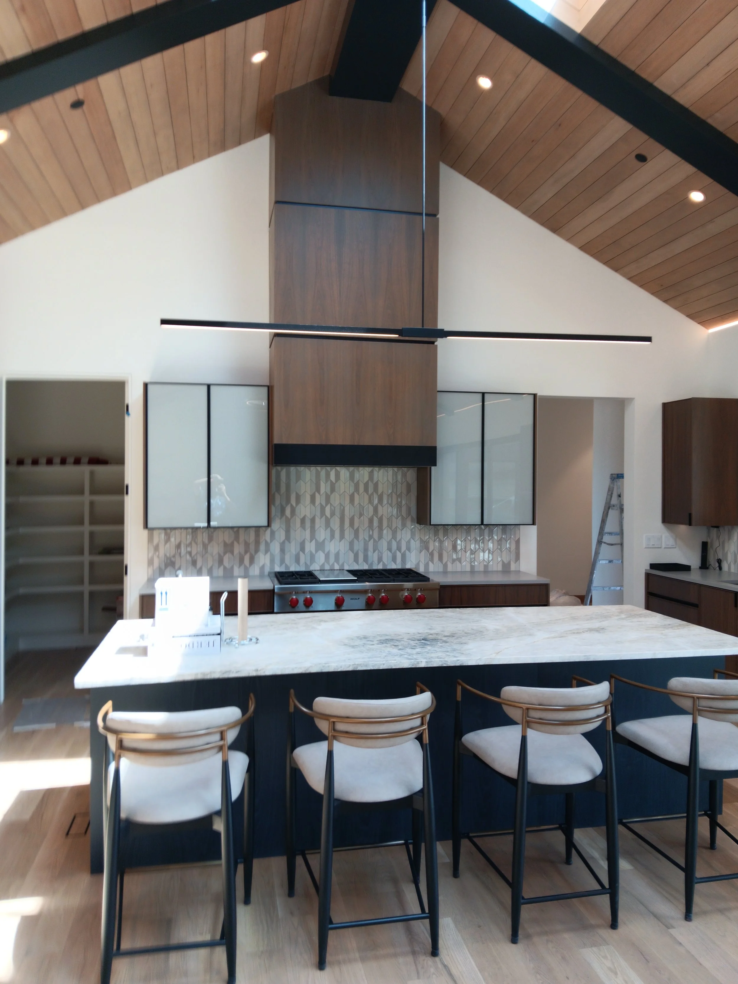Custom luxury kitchen island with live-edge wood waterfall countertop.
