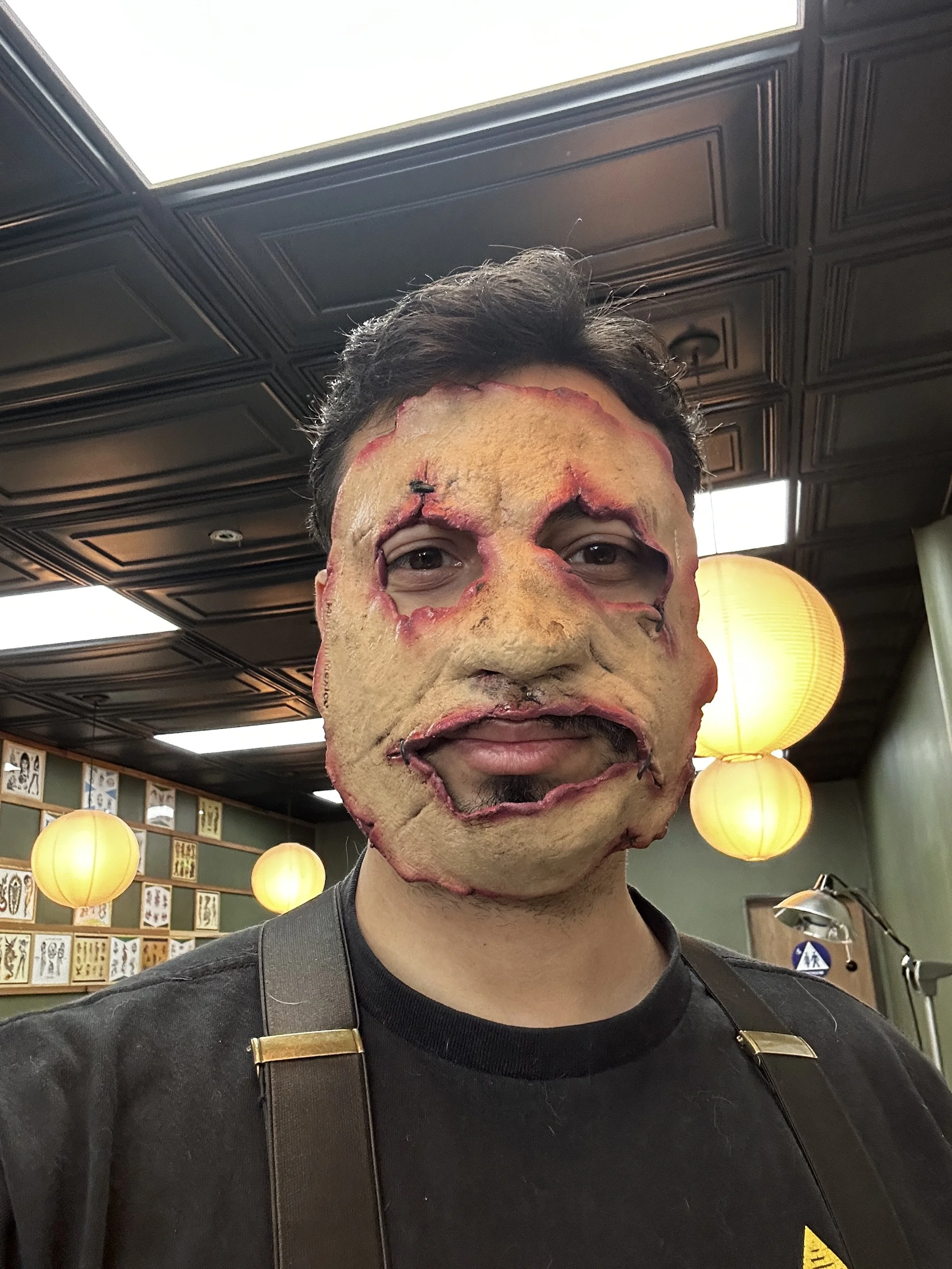 Person wearing a horror mask with a grotesque, stitched face.