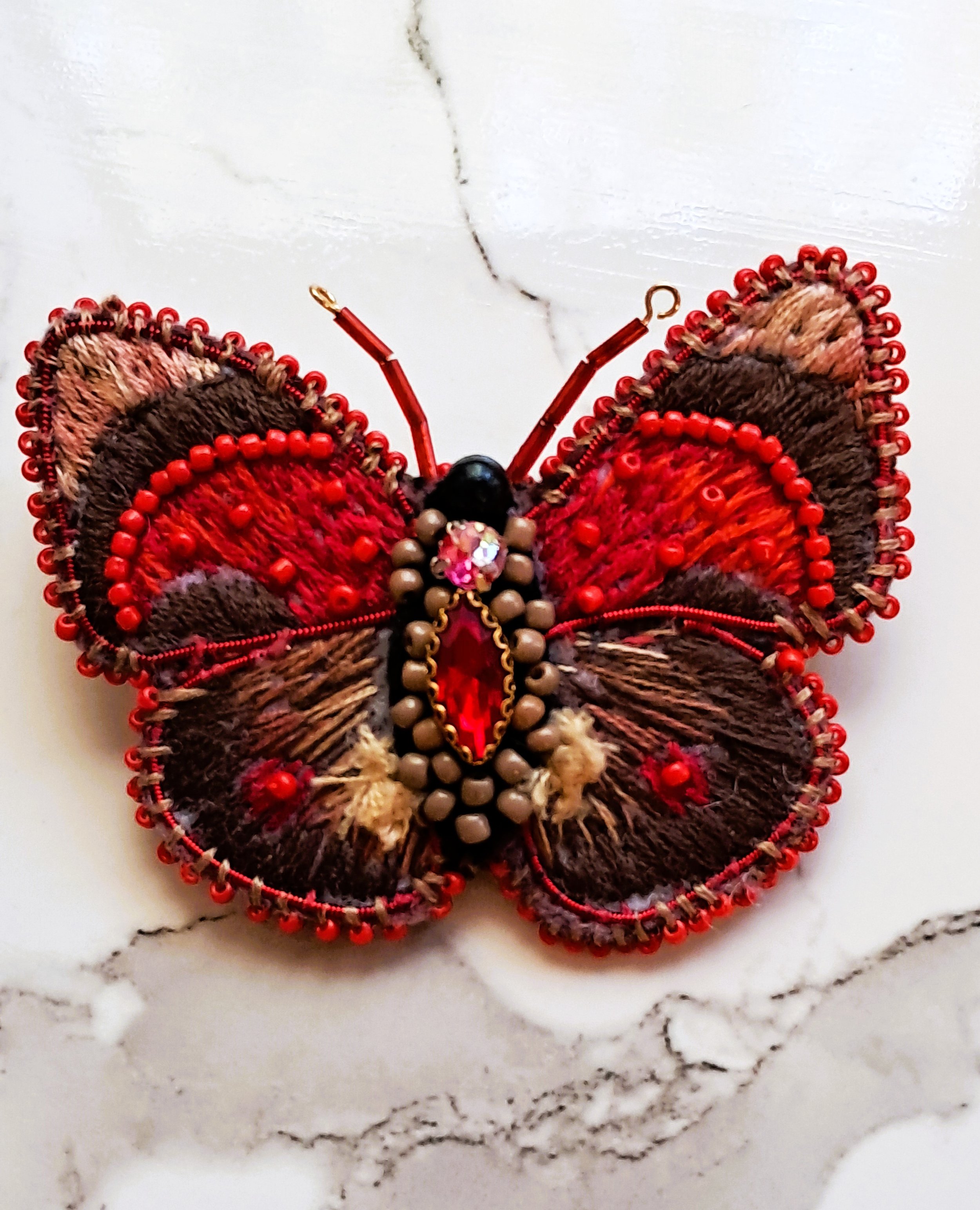 Schulze's Agrias butterfly is an embroidered and beaded butterfly brooch made by the brooch place.