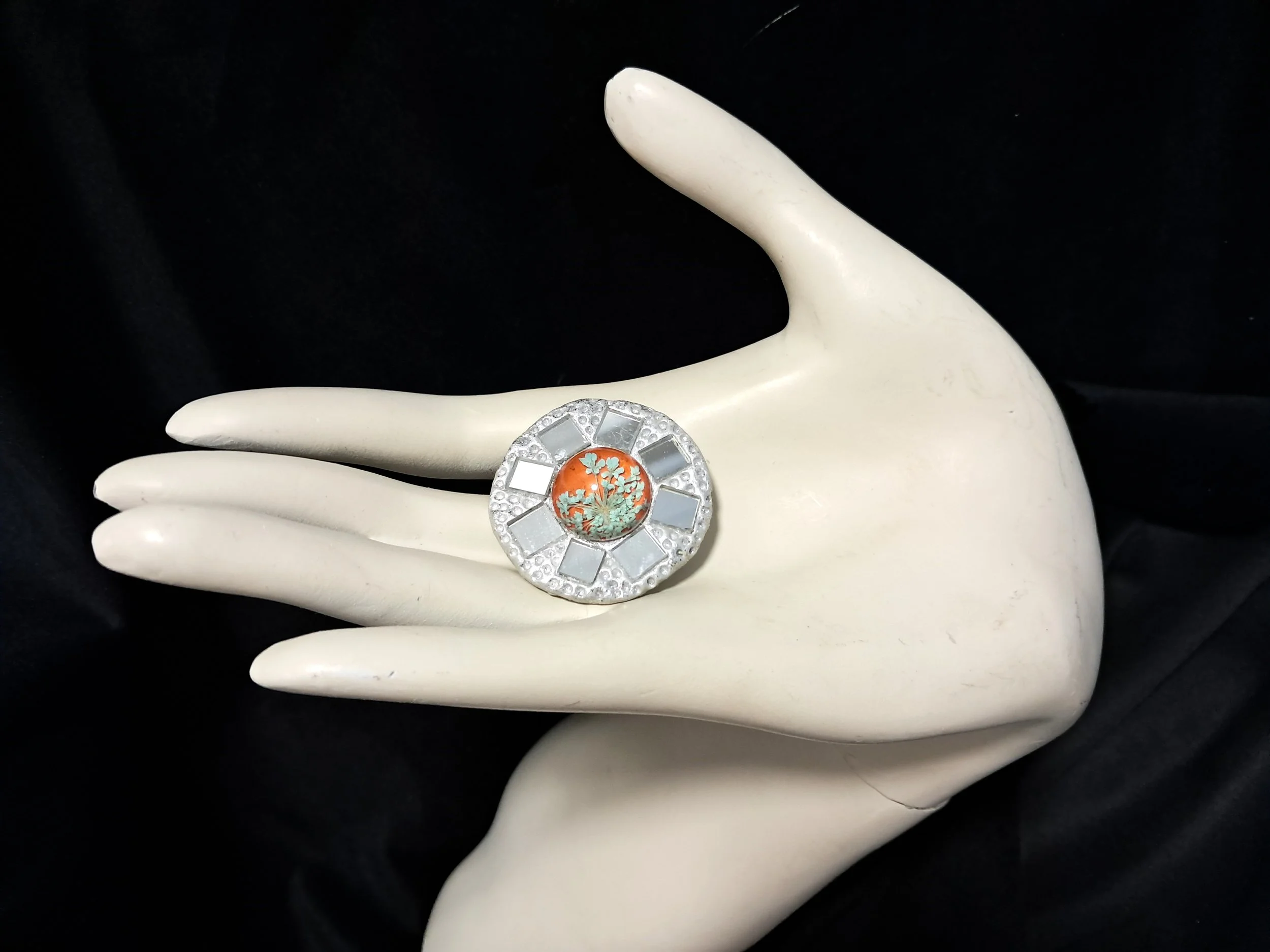 glass shield brooch orange hand.jpg