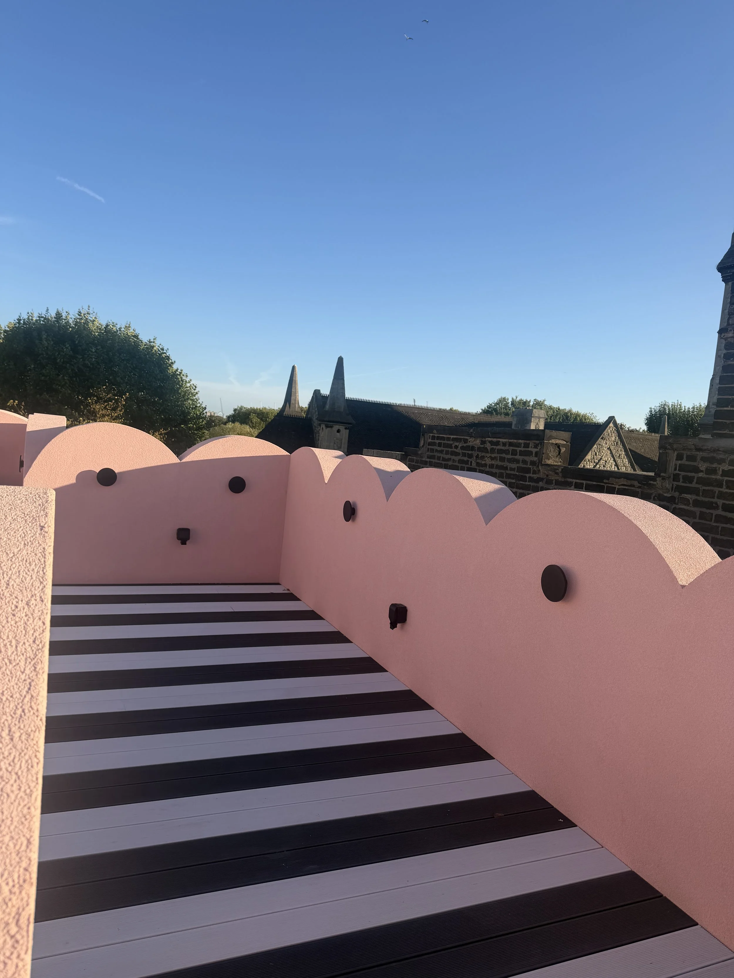 Striped rooftop terrace at Cloud House with distinctive scalloped pink walls and views across Gospel Oak