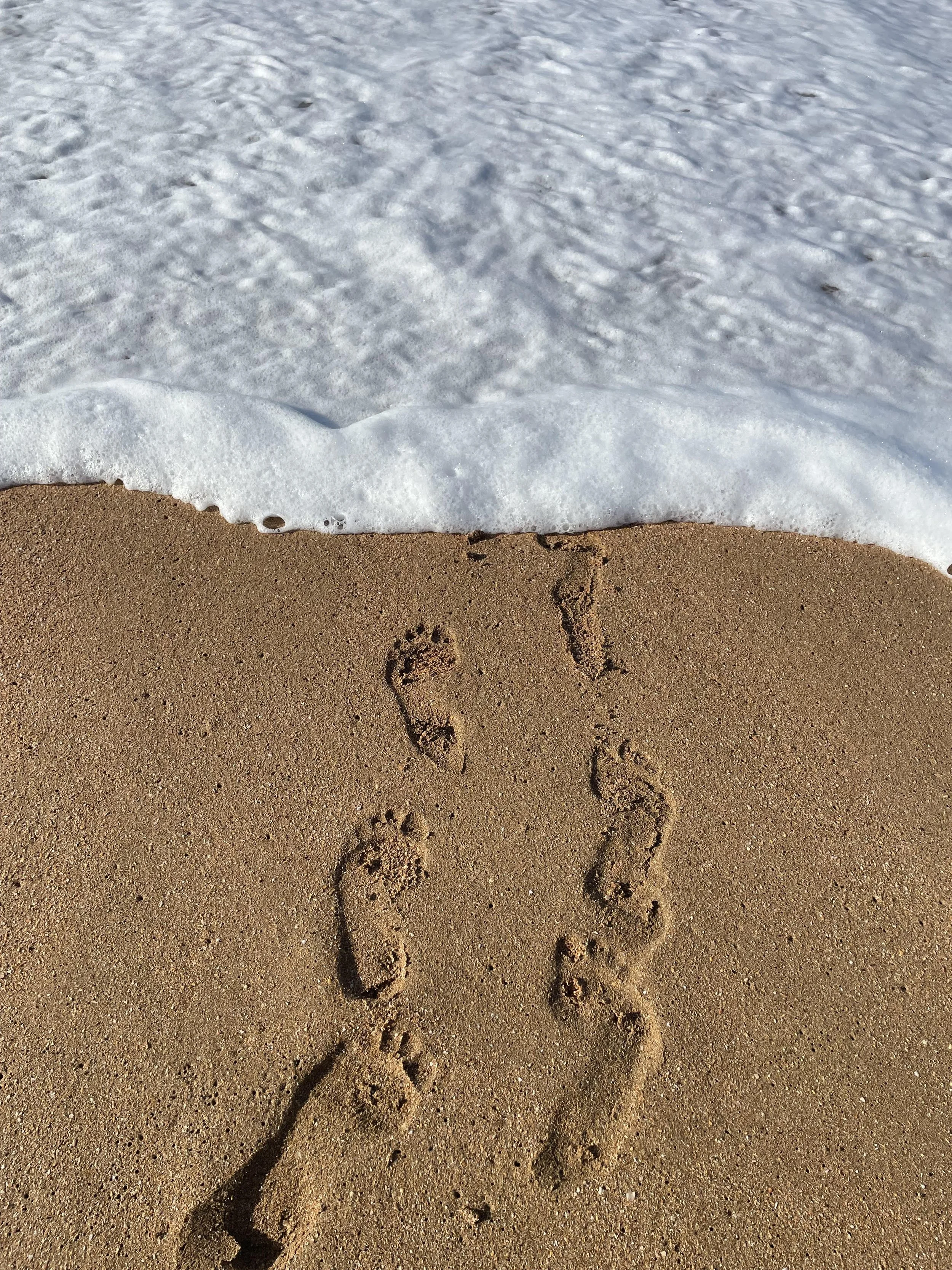footprints in sand to water