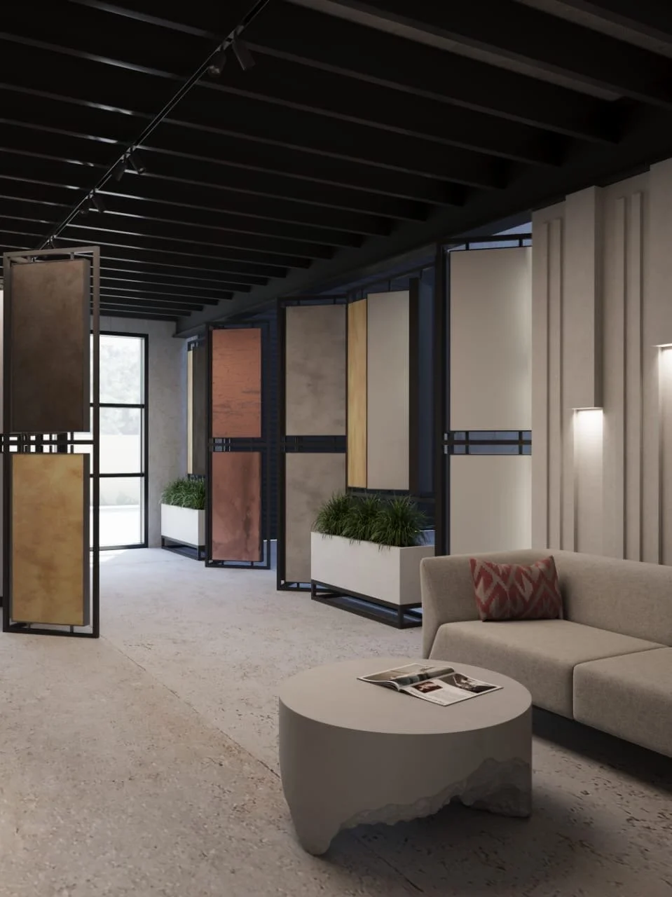 Modern interior space with a black ceiling and light-colored walls. Features a row of decorative panels or screens in various colors and textures, some with framed black metal supports. There are large windows with sunlight coming through, and tall white planters with greenery. A beige sofa with a patterned pillow is in the foreground, and a round stone coffee table with an open magazine on it.