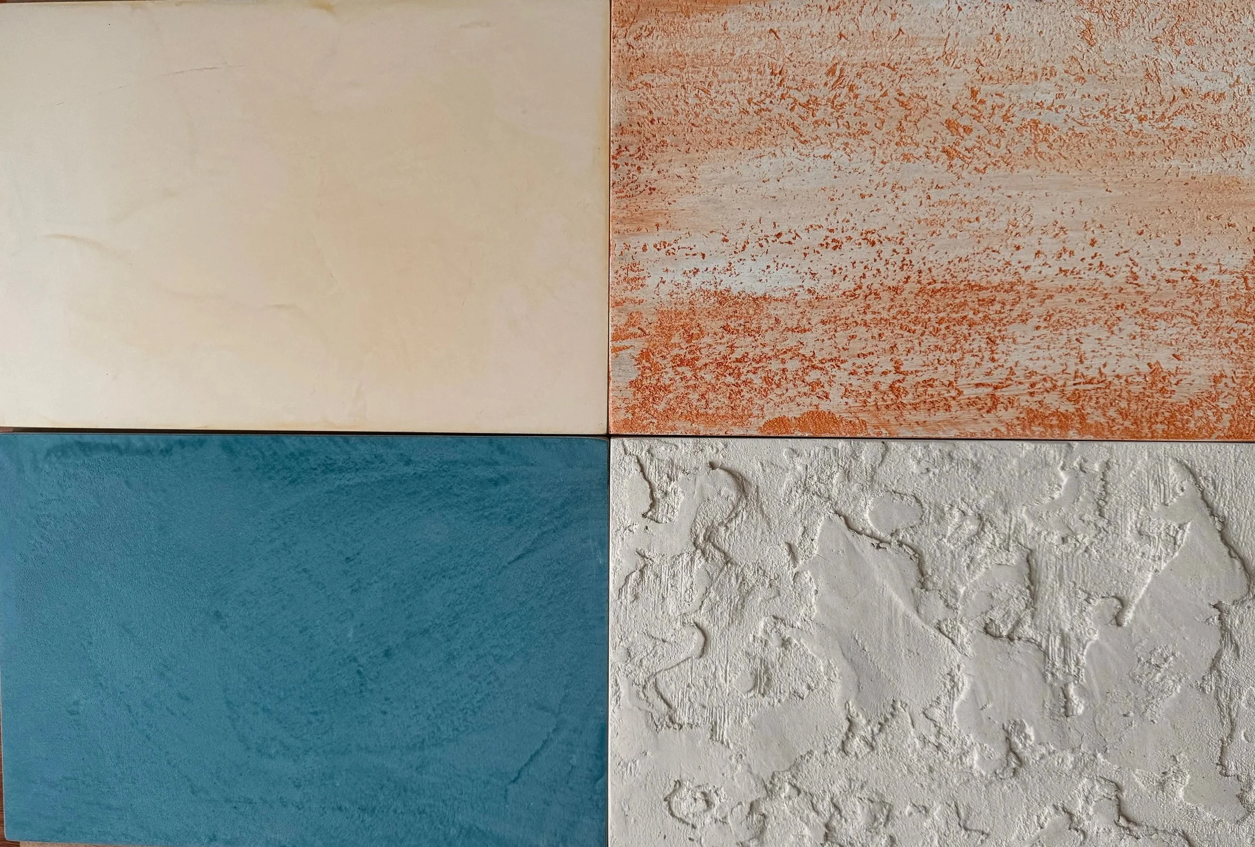 A tile arrangement with four different textured tiles: top left is smooth beige, top right is orange with reddish speckles, bottom left is smooth textured blue, and bottom right is rough white with a mottled pattern.