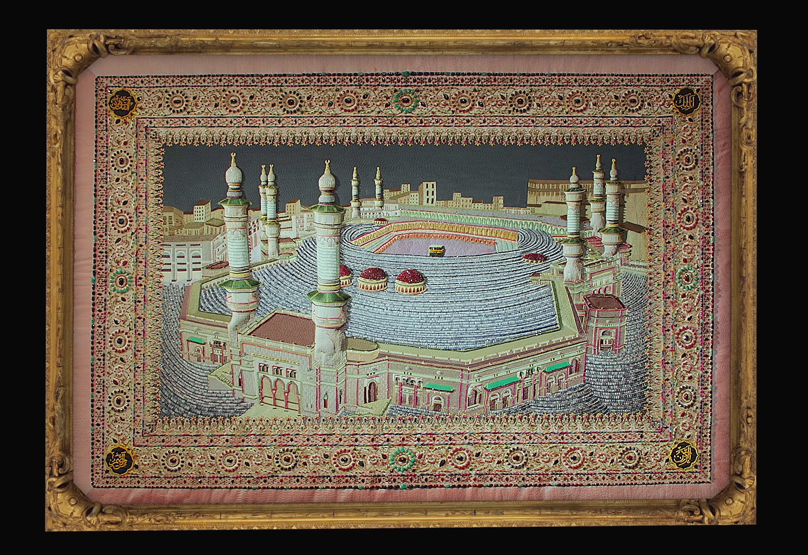 An ornate framed artwork depicting the Kaaba, a sacred Islamic structure in Mecca, surrounded by detailed decorative borders, with gold accents and floral patterns.