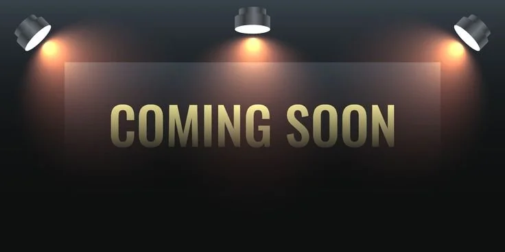 A dark wall with three spotlights shining down, illuminating the words 'COMING SOON' in large, gold letters.