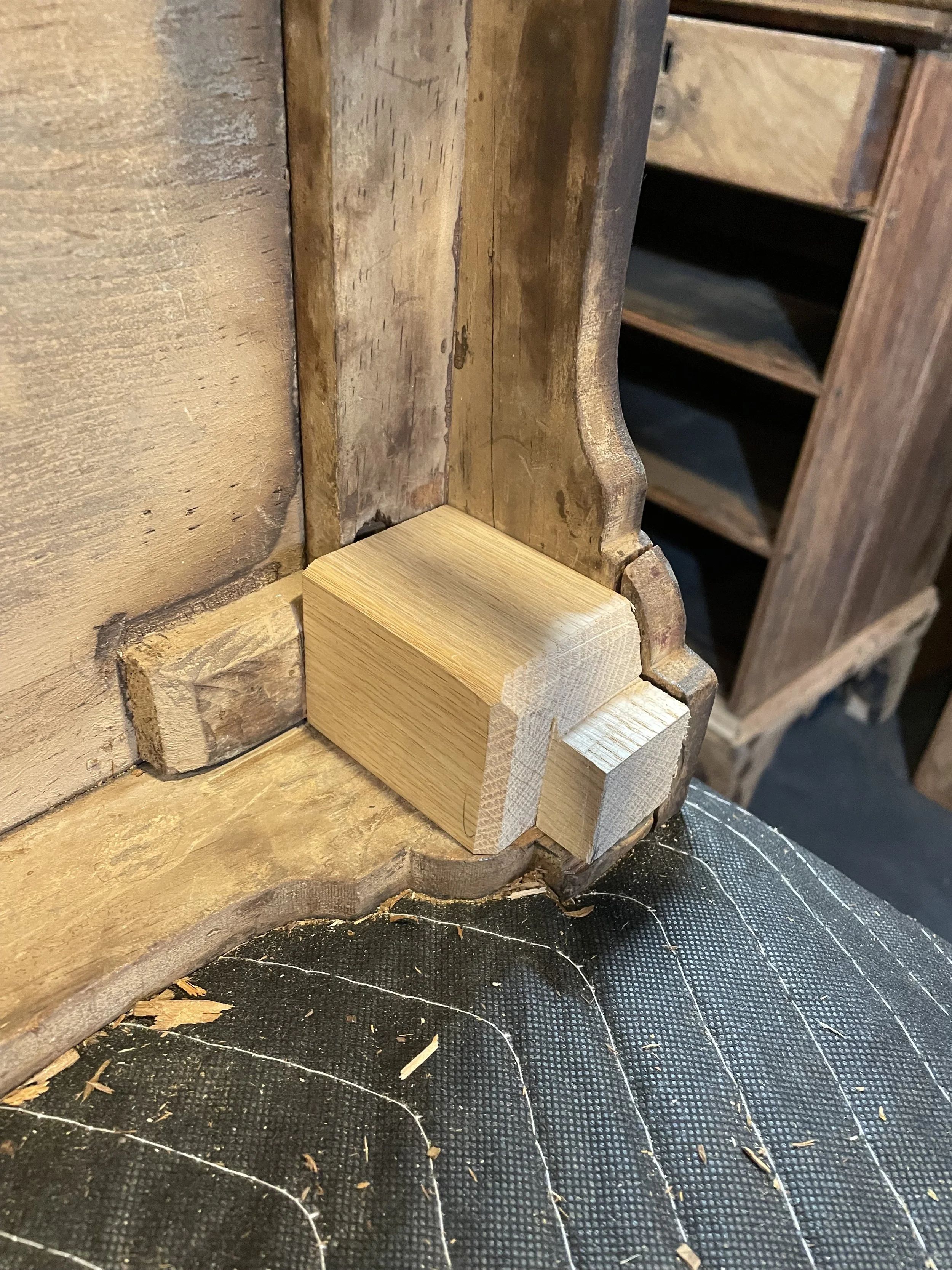 Fabricated new corner blocks out of one solid piece of oak. Large enough that it would transfer the load to the case, but terminating on the floor with a profile to fit the piece. 