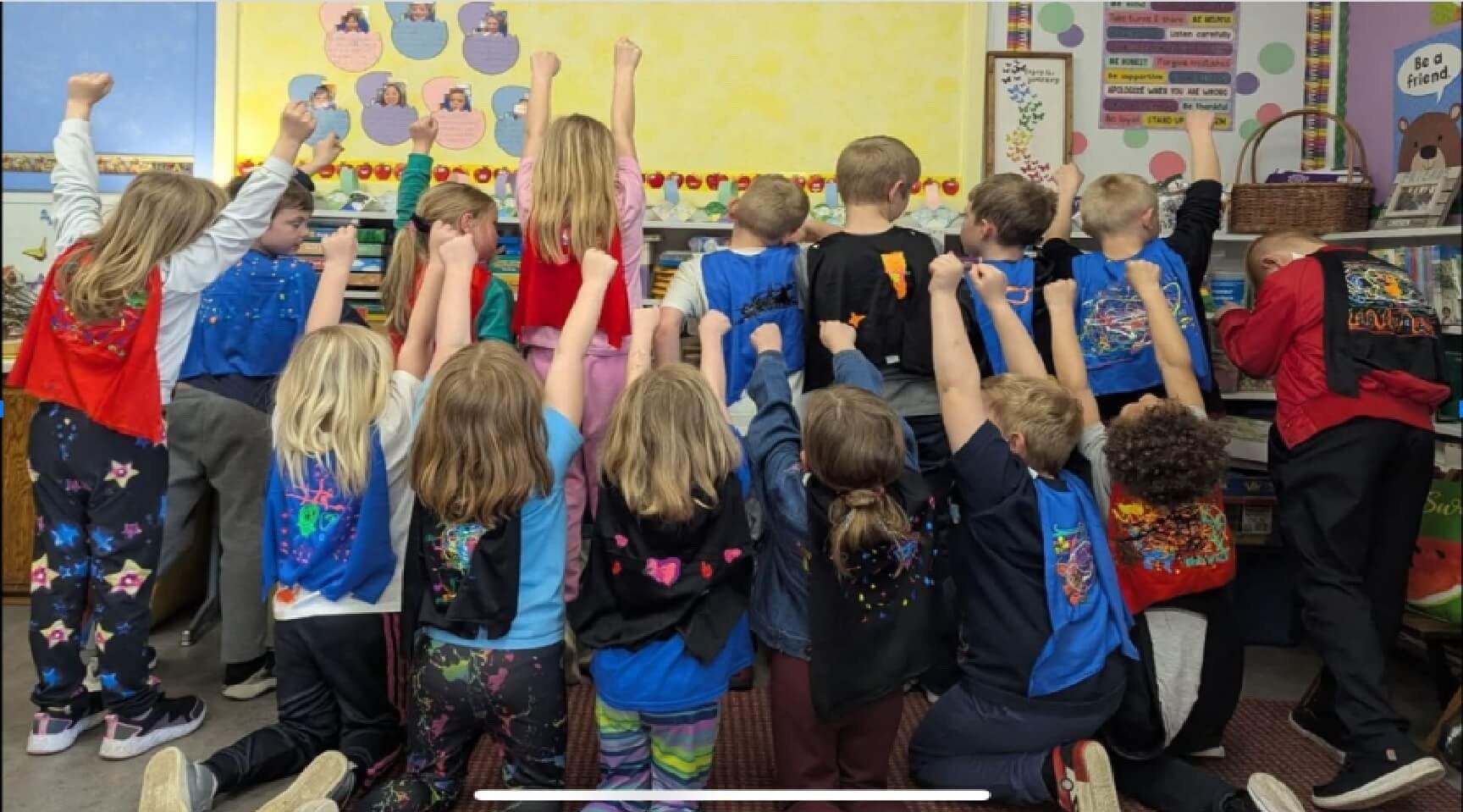 Elementary students raising their hands together in a Wisconsin classroom