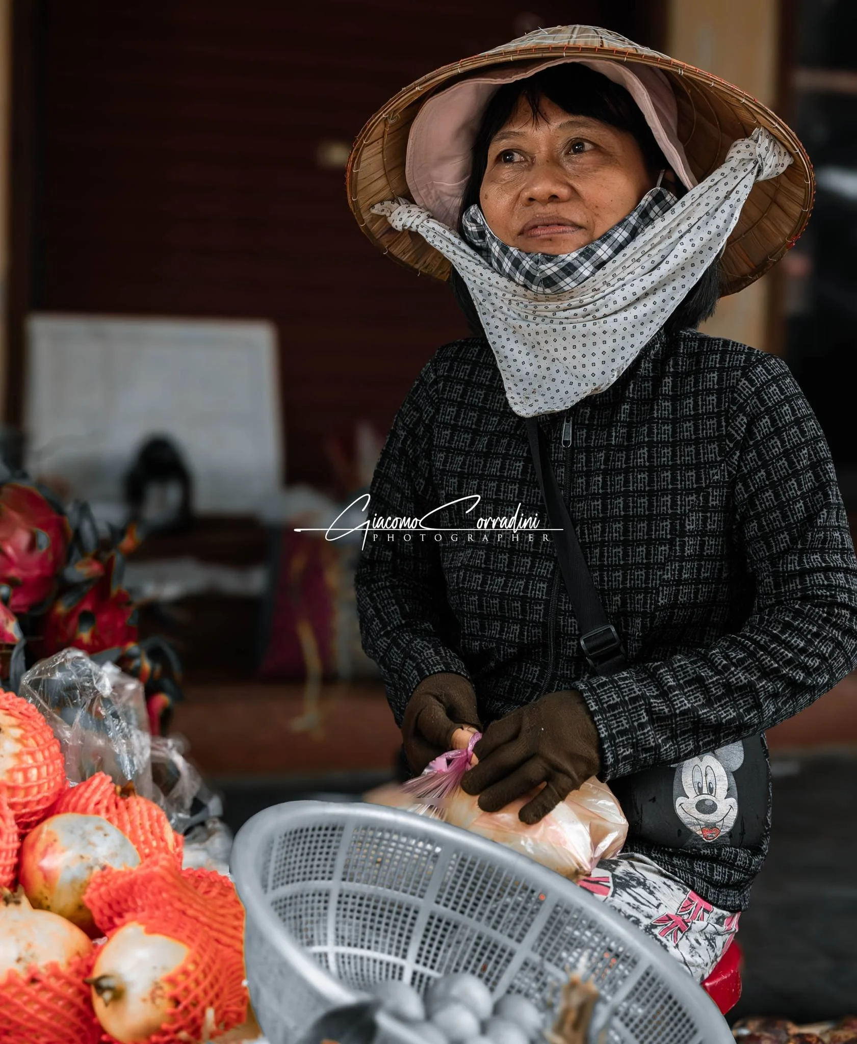 Donna infreddolita al mercato con cesto di frutta, Hanoi Vietnam Wild Travel Films