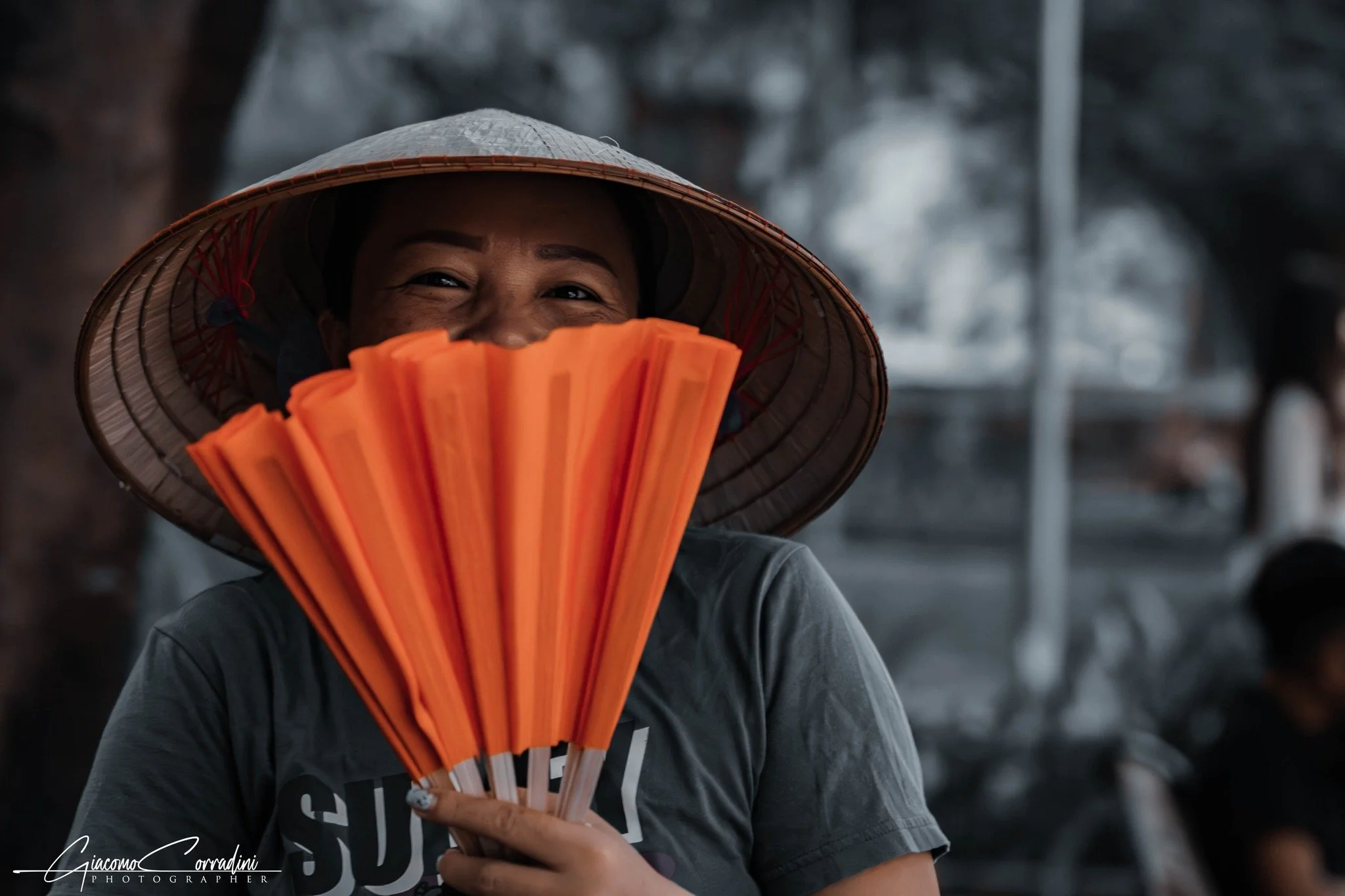 Volto parzialmente nascosto da un ventaglio arancione, Hanoi Vietnam Wild Travel Films