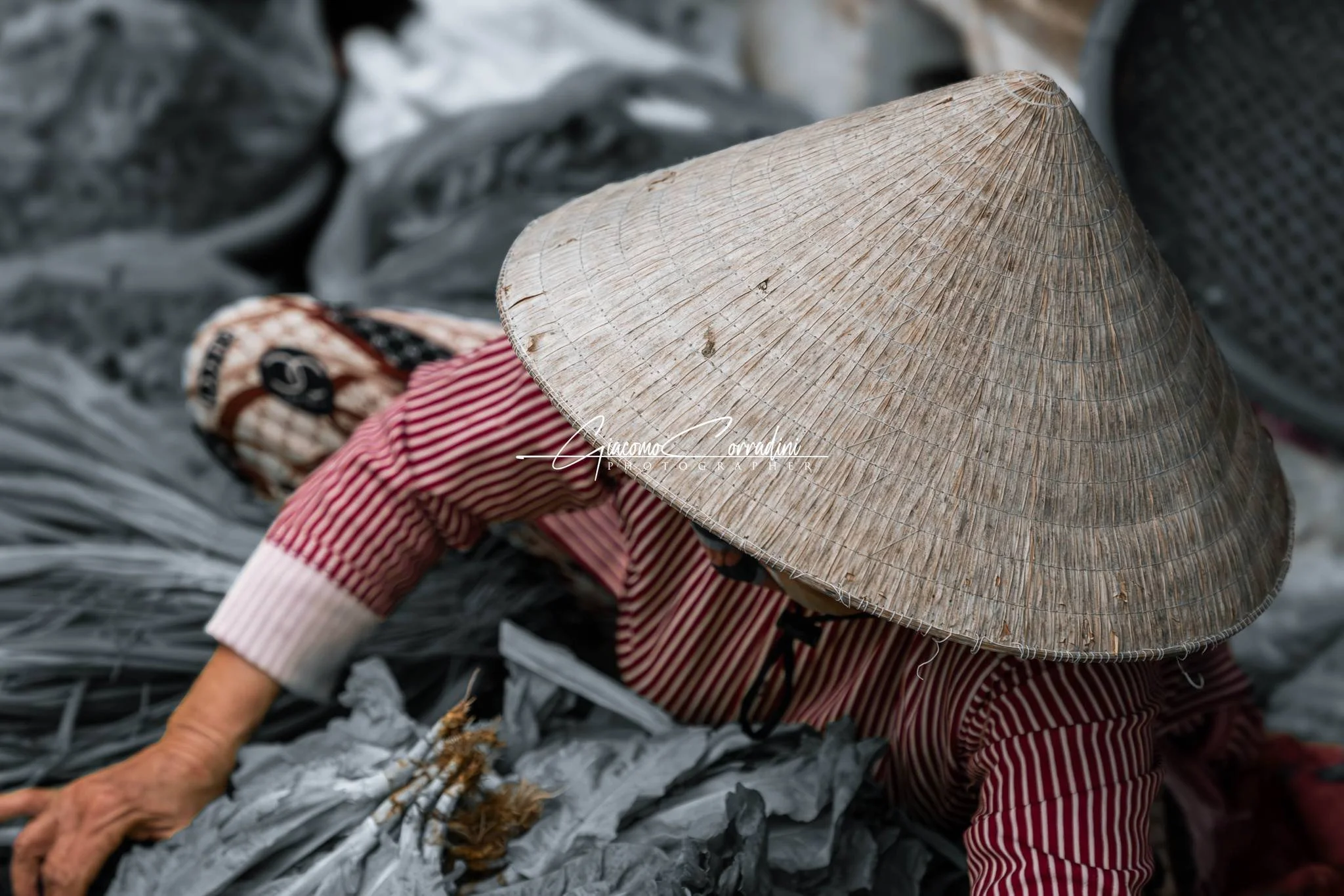 Donna con cappello conico smista sacchi di riciclo, Hanoi Vietnam Wild Travel Films
