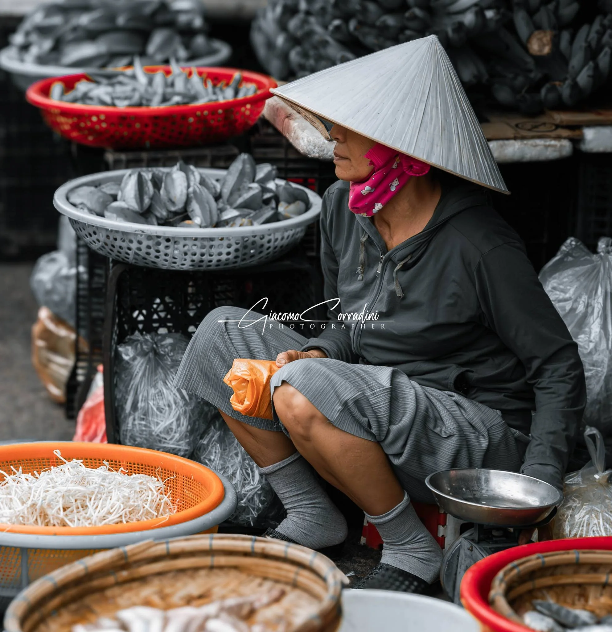 Venditrice di cibo di strada con mascherina tra ceste colorate, Hanoi Vietnam Wild Travel Films