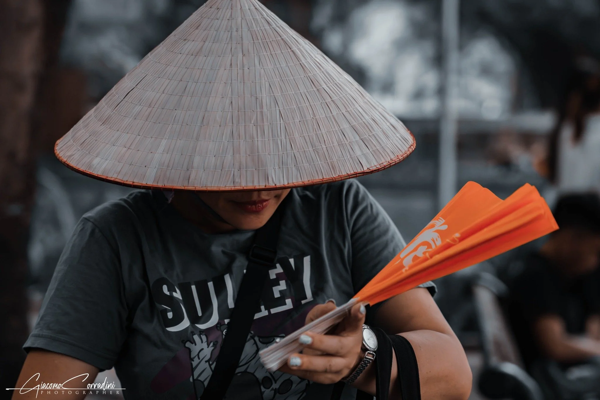 Ritratto con cappello conico e ventaglio arancione, Hanoi Vietnam Wild Travel Films