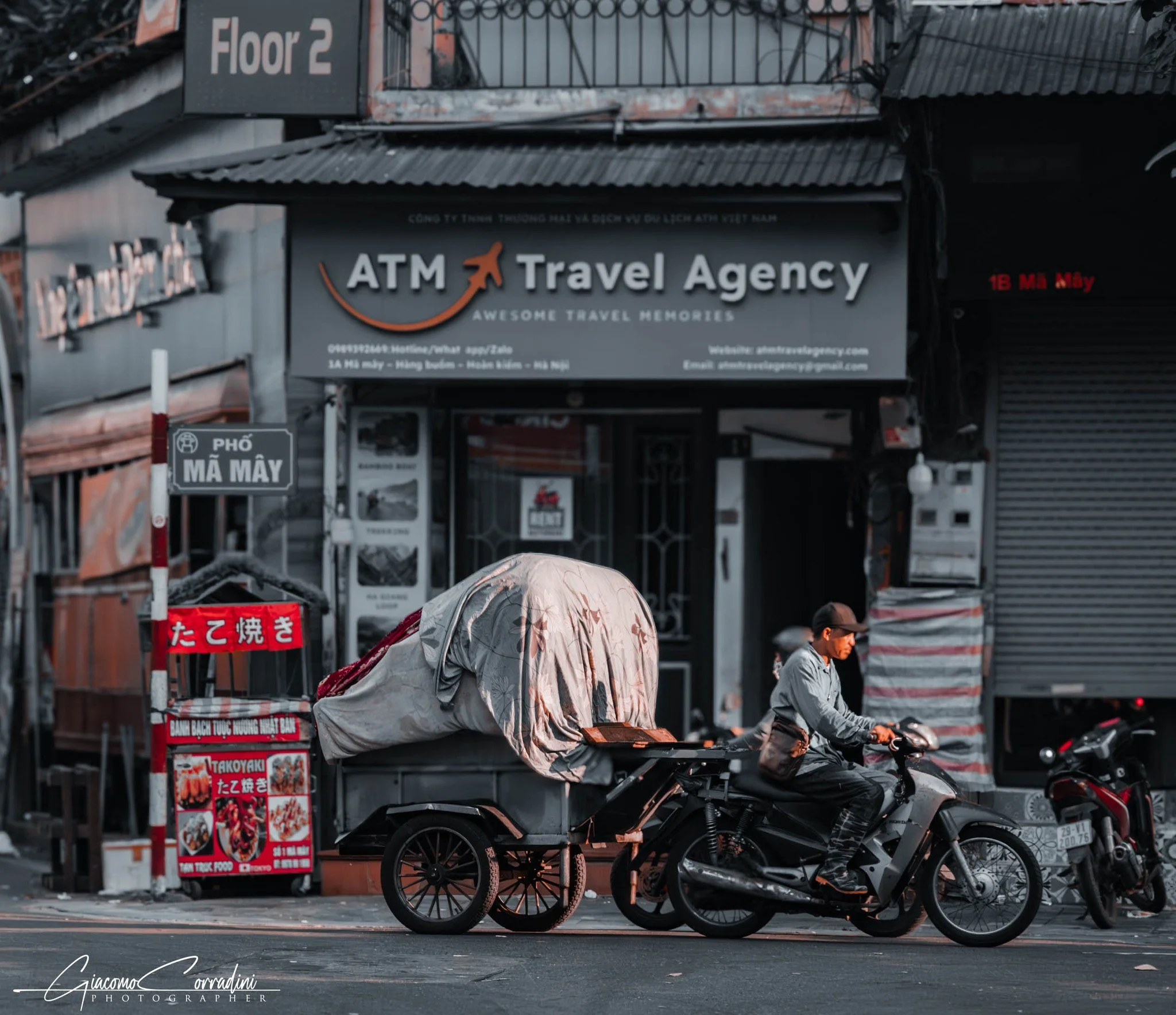 Scooter carico all'angolo di una via commerciale, Hanoi Vietnam Wild Travel Films