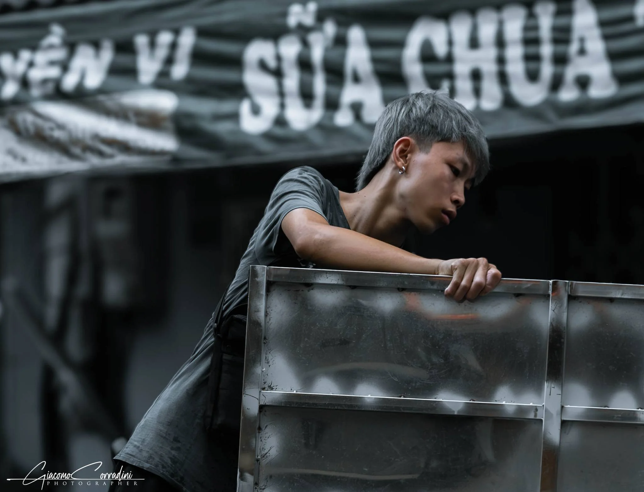 Lavoratrice trasporta blocchi di ghiaccio davanti a un'insegna di riparazioni, Hanoi Vietnam Wild Travel Films