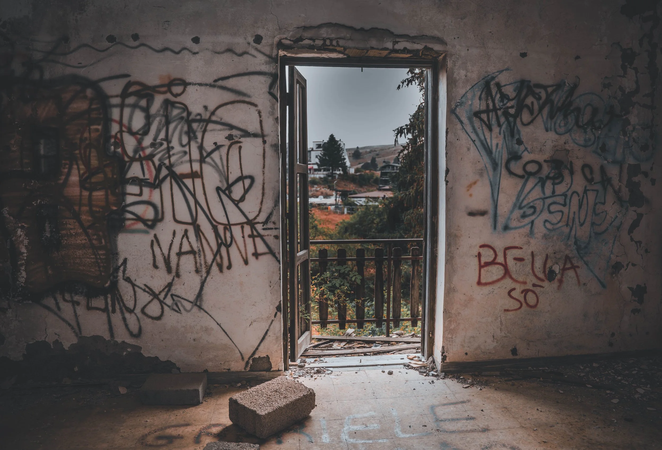 Porta d'ingresso con graffiti che incornicia la vista sul paesaggio, Where Silence Lives Wild Travel Films