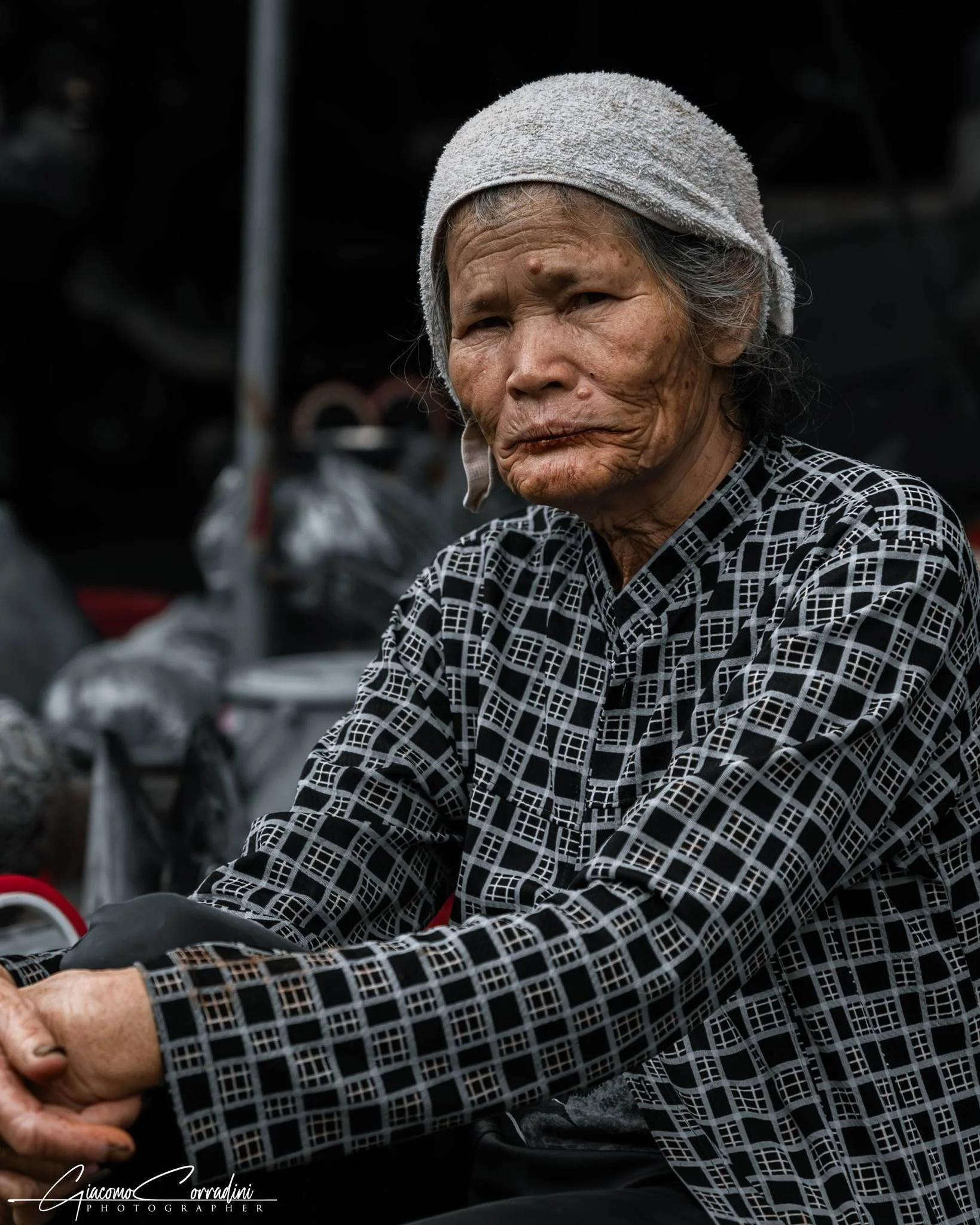 Ritratto di anziana al mercato con le mani intrecciate, Hanoi Vietnam Wild Travel Films