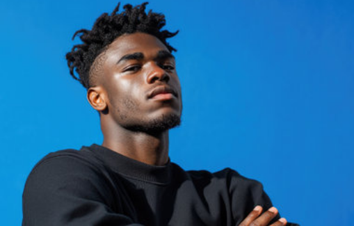 Young man with crossed arms against a blue background
