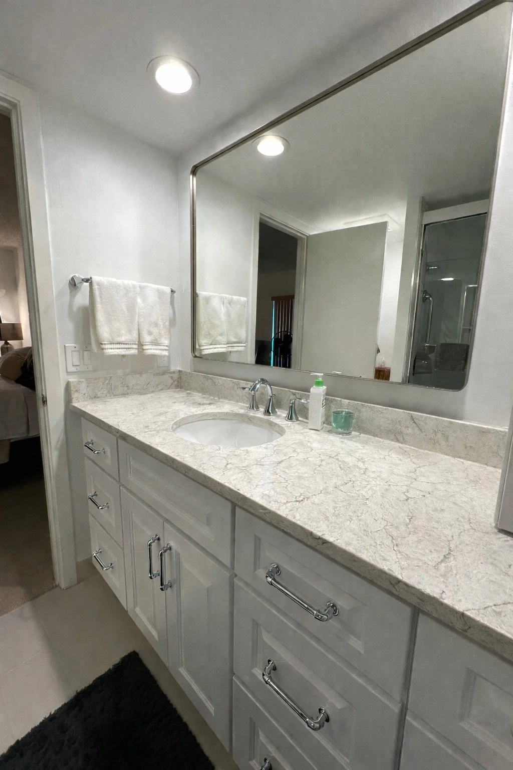 This remodel with a new bright vanity and stunning quartz countertop offers a timeless appeal. The functional layout provides ample storage and a clean, fresh aesthetic.