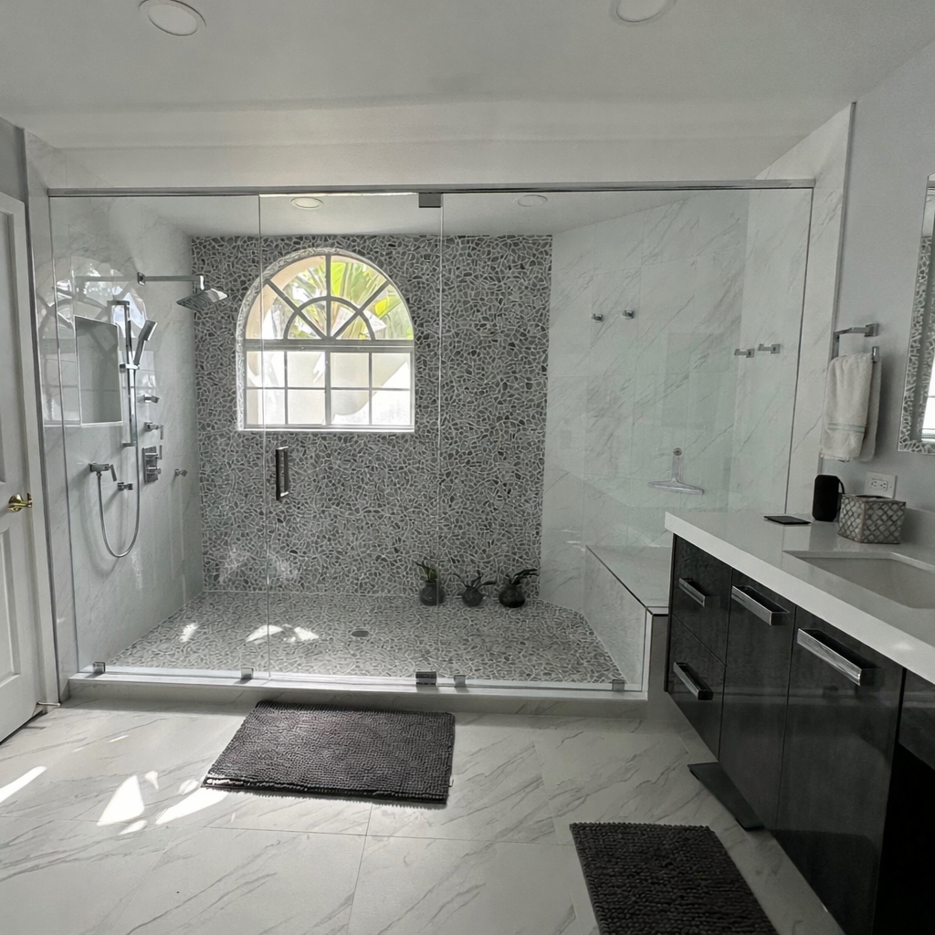A very spacious shower featuring a mosaic accent wall serves as the focal point of this spa-inspired bathroom retreat. The arched window floods the space with natural light enhancing the refined and contemporary atmosphere.