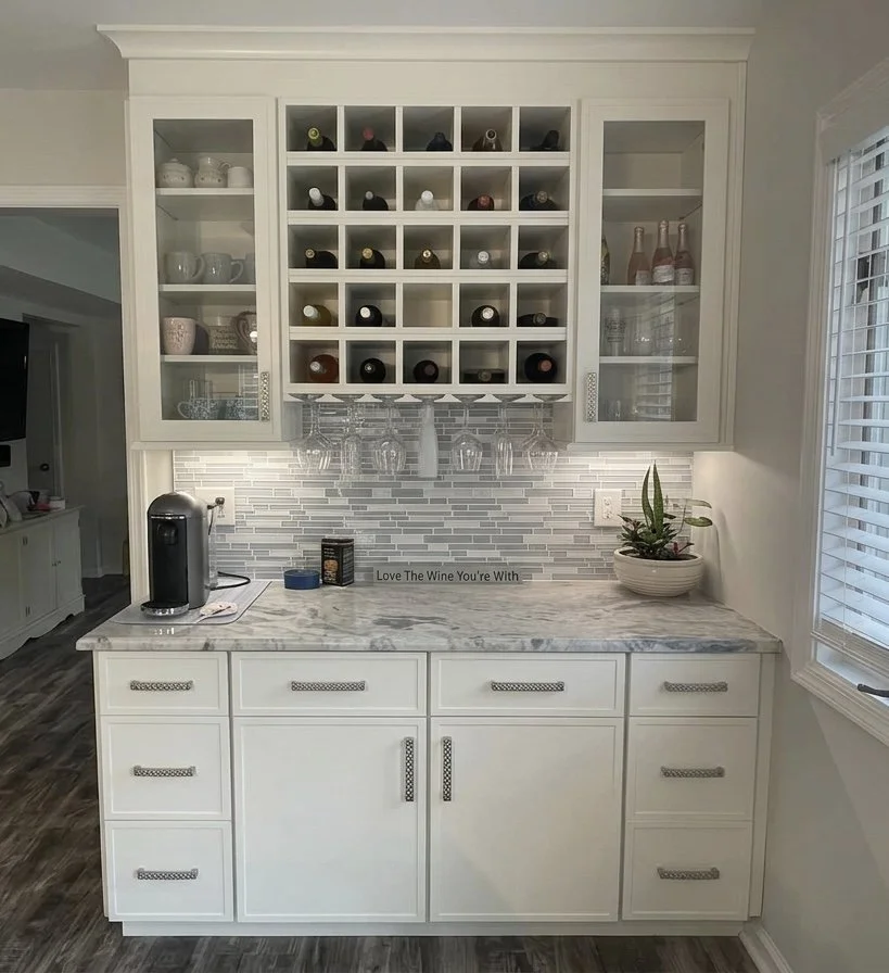 This custom beverage station utilizes an updated shaker style cabinet, elegant glass display, integrated wine storage and under cabinet lighting to create a refined, functional focal point in this kitchen.