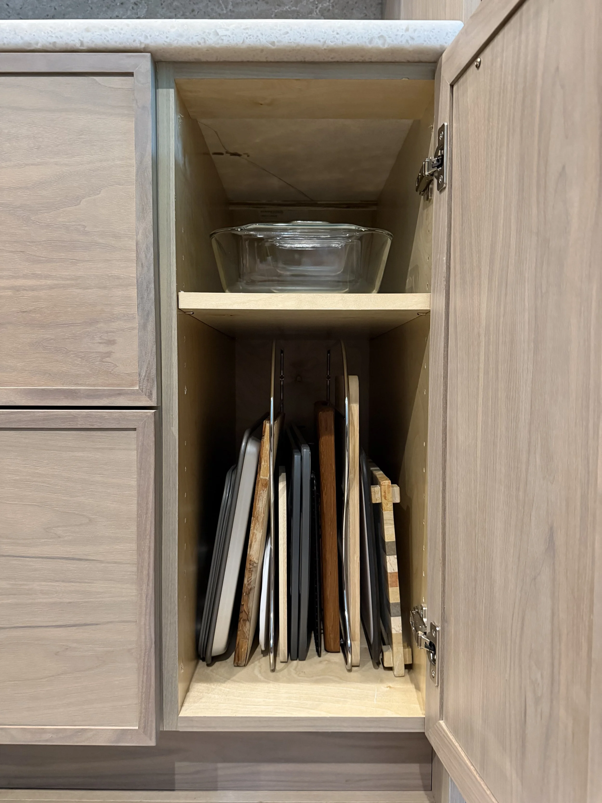 Installed vertical dividers maximize narrow cabinet space, keeping cutting boards, baking sheets and serving trays neatly upright and easily accessible.
