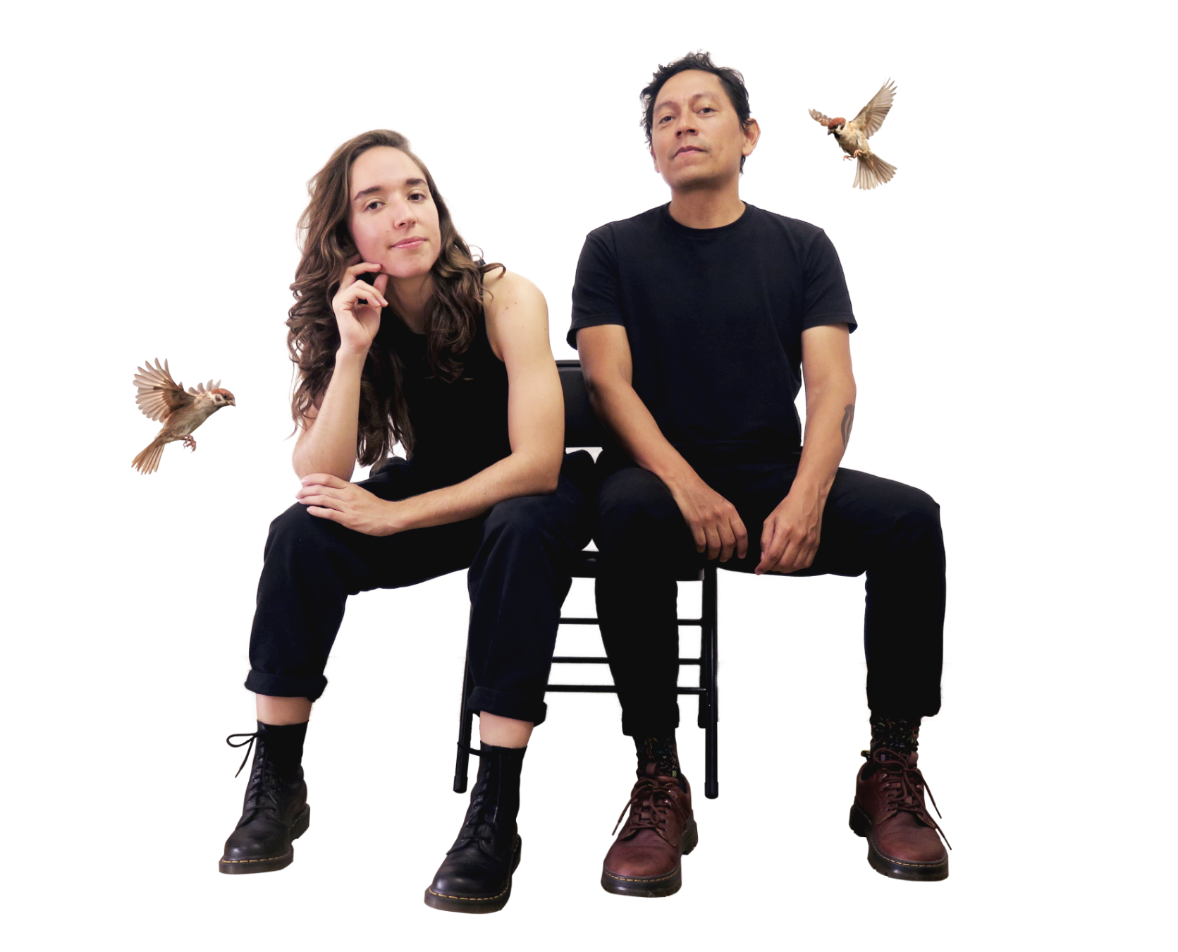 Camila Borrero y Alexander Wtges, directores de Amazing Design Studio. En su estudio de Diseño Amazing sentados en una silla, ambos con ropa negra, rodeados de dos gorriones en vuelo, en un fondo blanco.