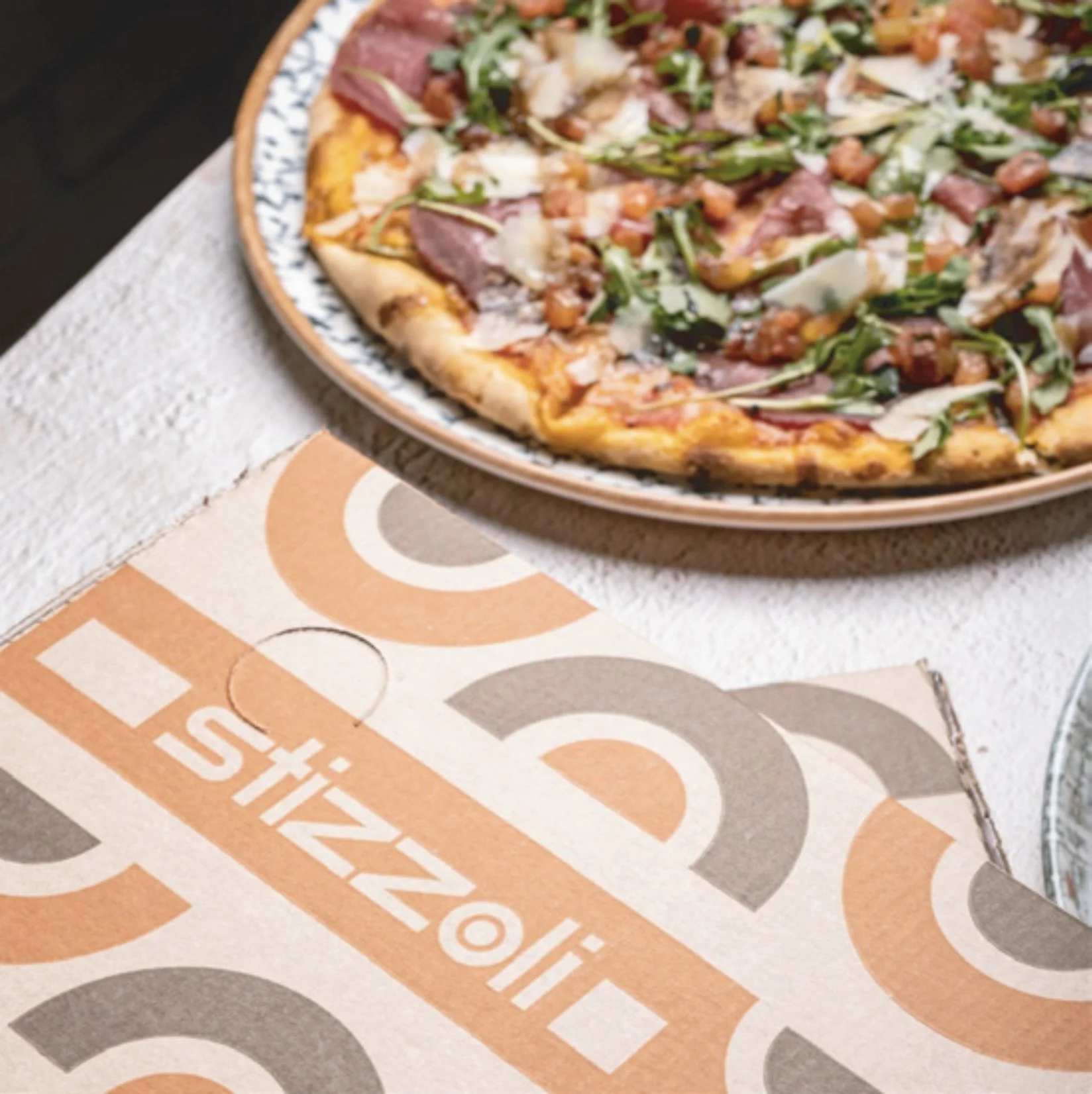 pizza y caja de piza con logotipo de stozzoli y la identidad diseñada por Alexander Wtges de Amazing creative design estudio de diseño grafico en panama